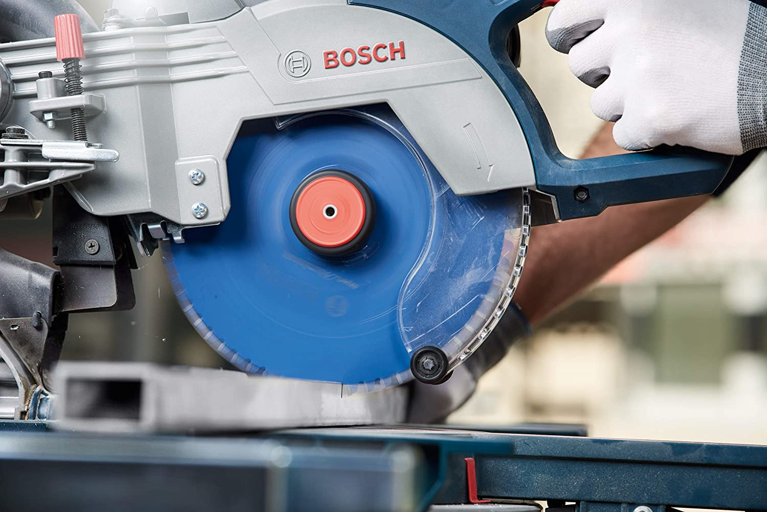 Eine Person, die eine Metallstange mit einer blauen Kreissäge schneidet. Die Säge ist mit BOSCH beschriftet.