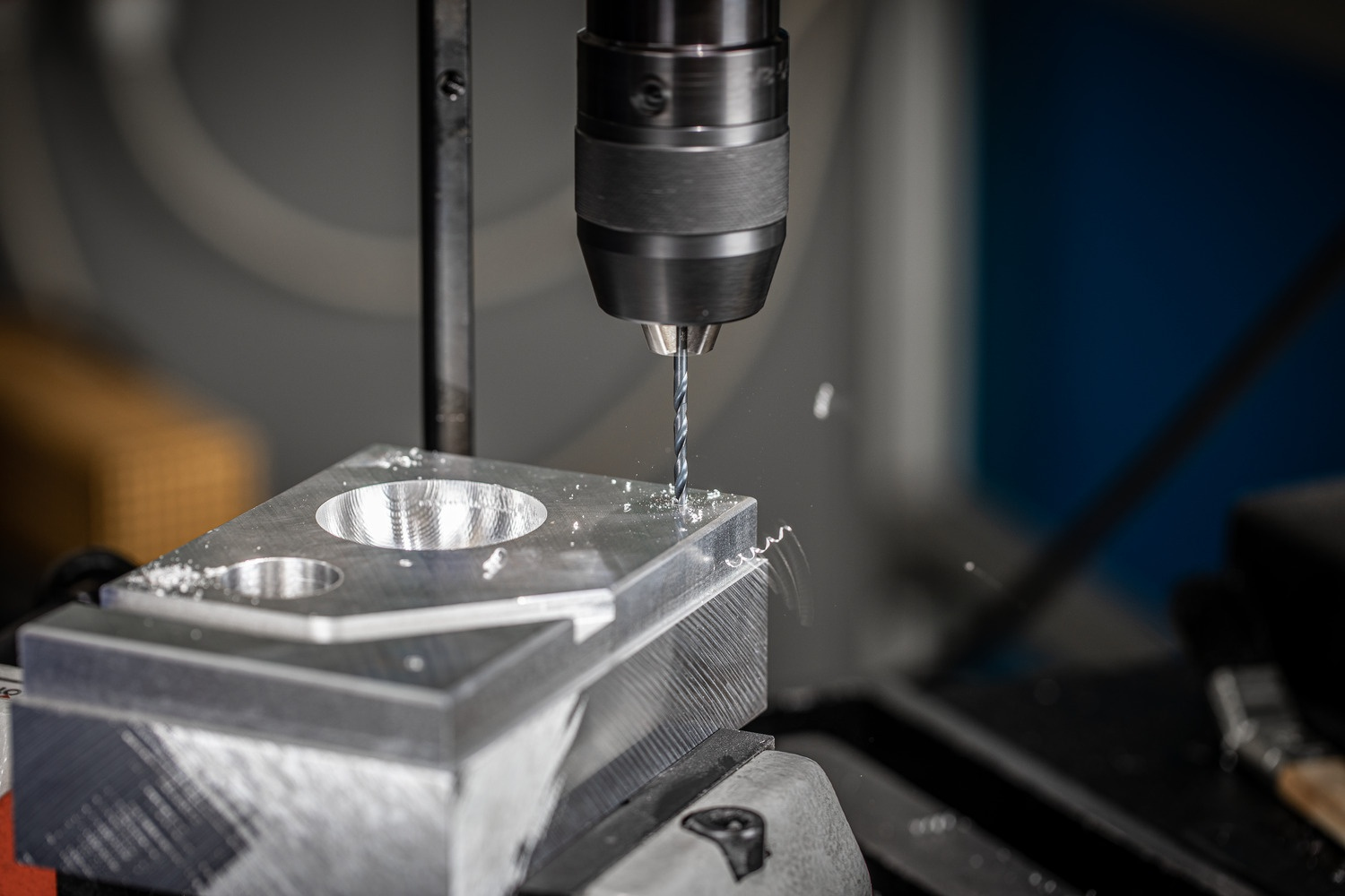 Ein Bohrer bohrt in einen Metallblock. Nahaufnahme.