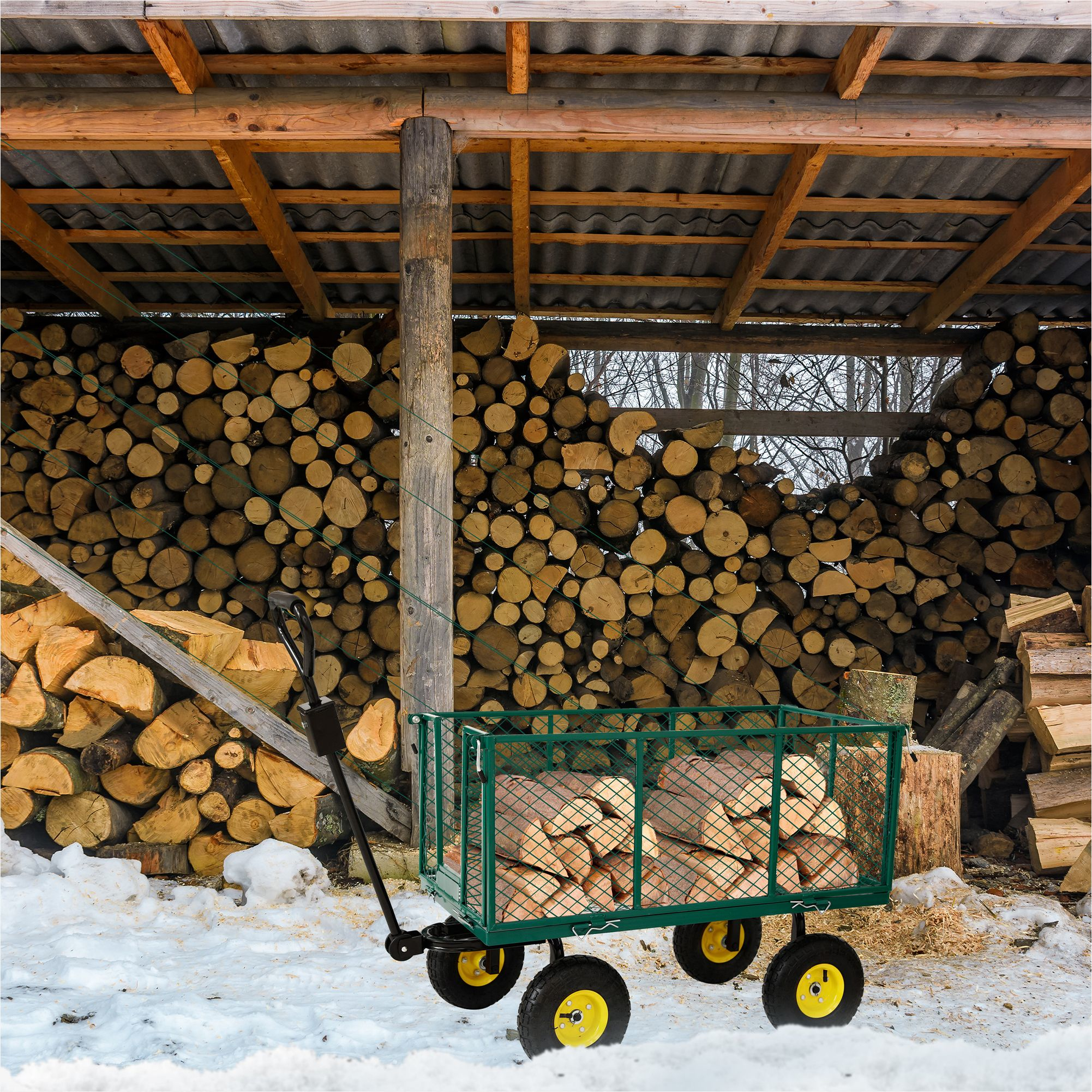 Ein grüner Wagen voller Holzstämme steht vor einer Wand aus gestapelten Holzstämmen unter einem Holzdach.