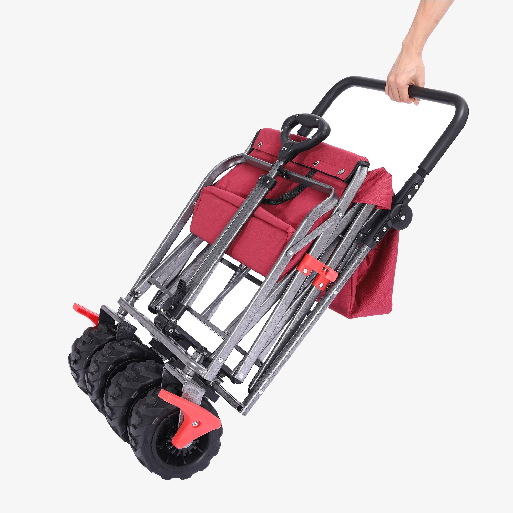 Zusammenklappbarer roter Wagen, der von einer Hand gehalten wird. Die Räder sind schwarz.