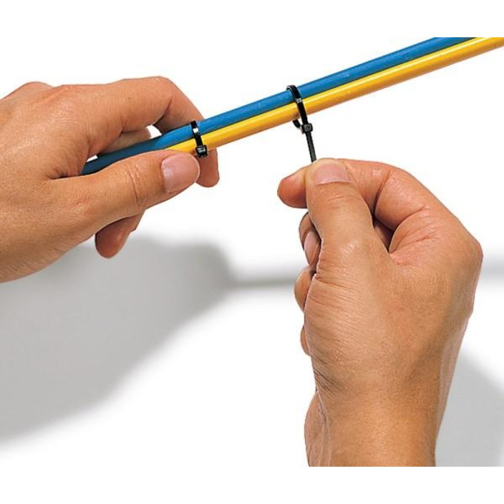 Hände verwenden einen schwarzen Kabelbinder, um zwei Kabel, blau und gelb, zu sichern.