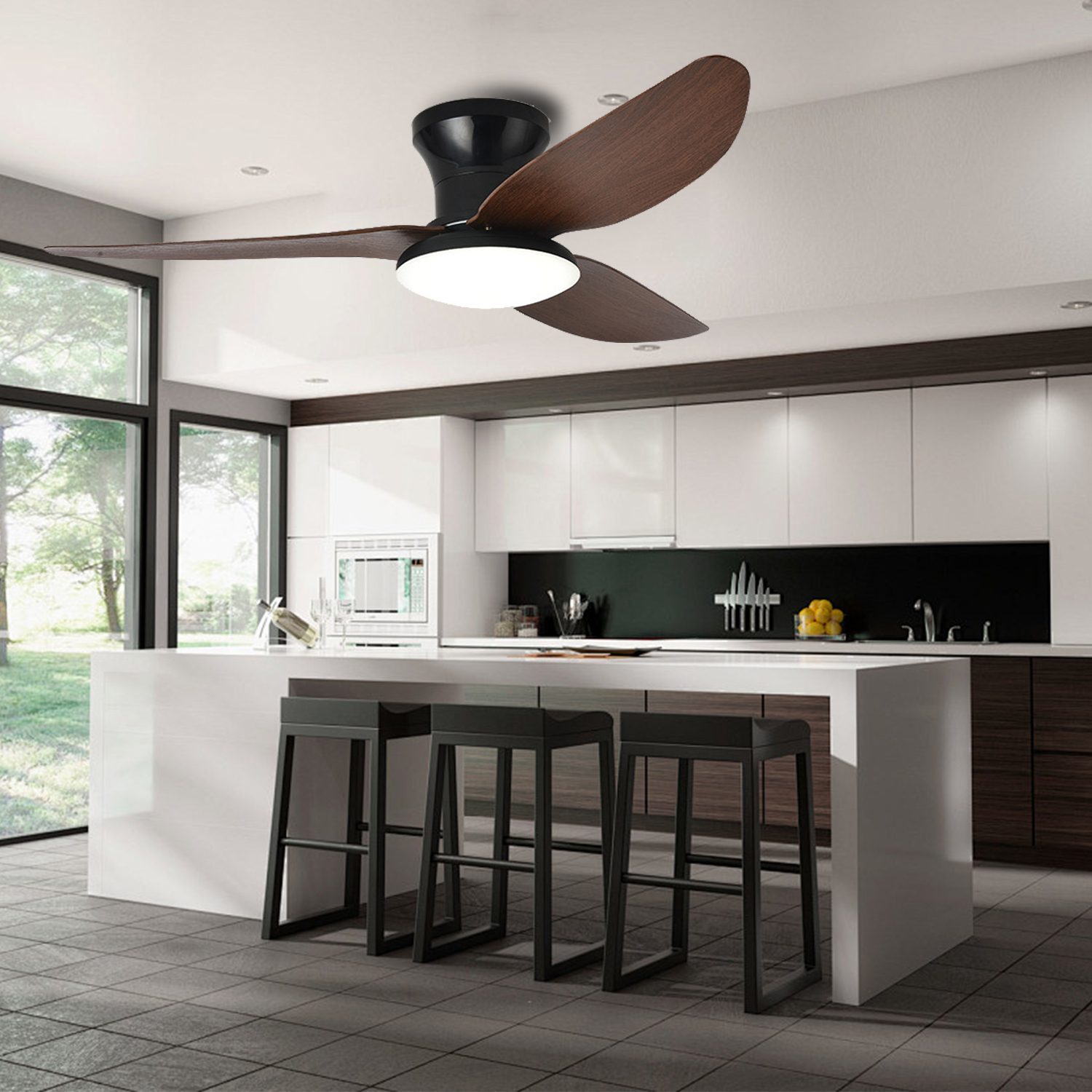 Eine Küche mit Deckenventilator, Insel mit Hockern und großen Fenstern.