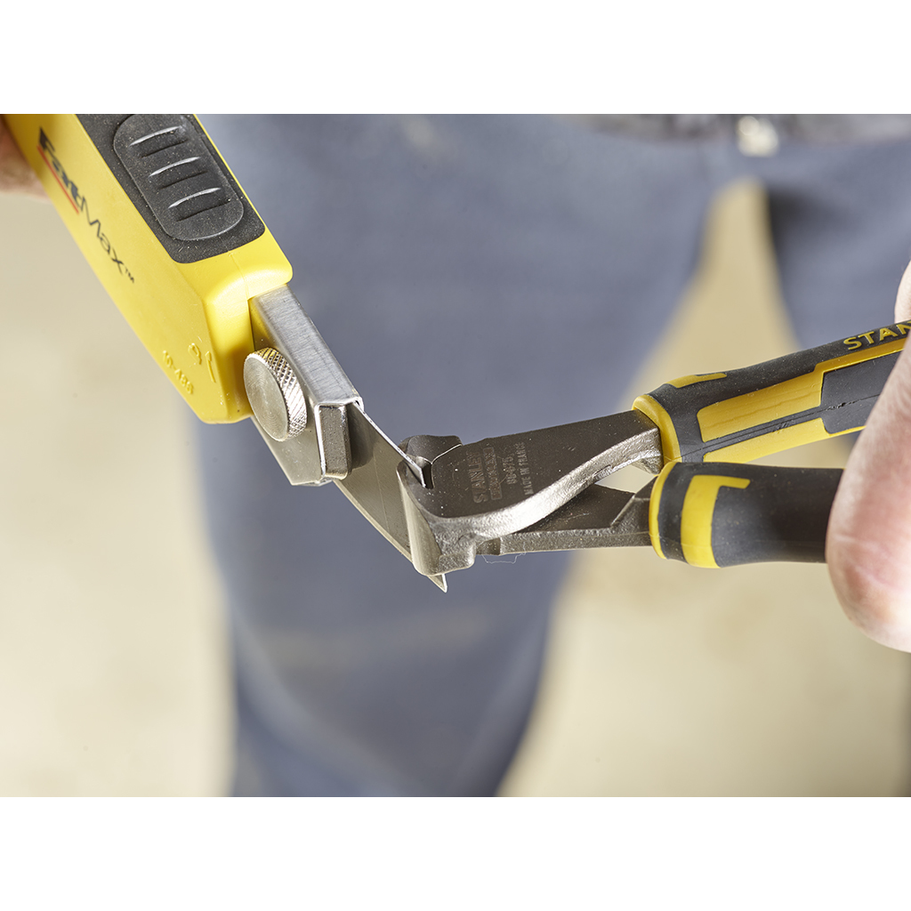 Persona usando un cuchillo Stanley para cortar un trozo de madera.
