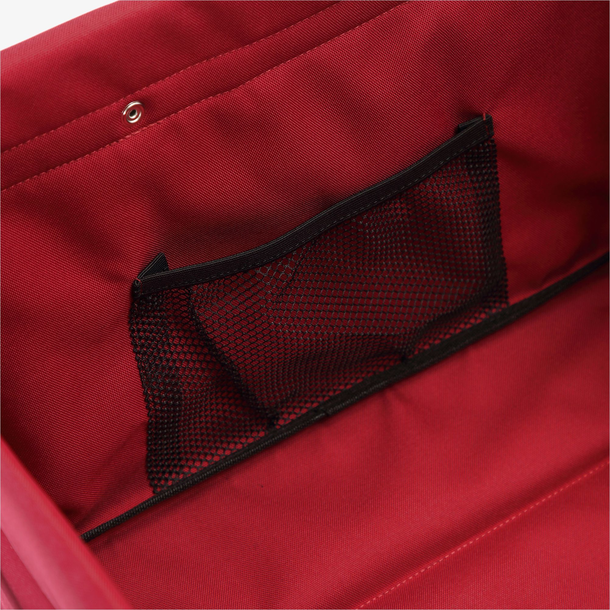 In einer roten Tasche ist eine schwarze Netztasche sichtbar. Das Innere der Tasche hat eine glatte Textur.