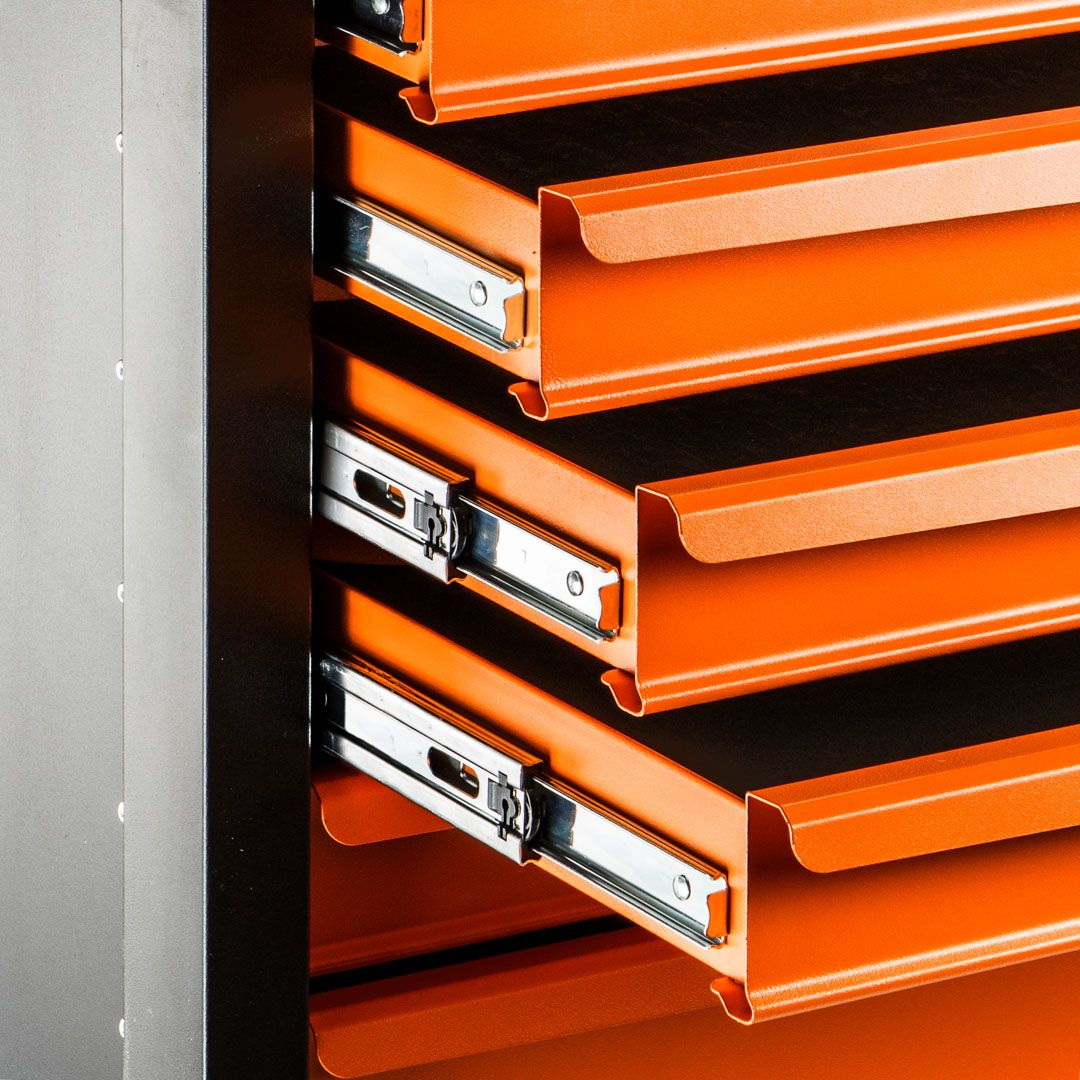 Orange Werkzeugschrank-Schubladen. Silberne Schienen sind sichtbar. Weißer Hintergrund.
