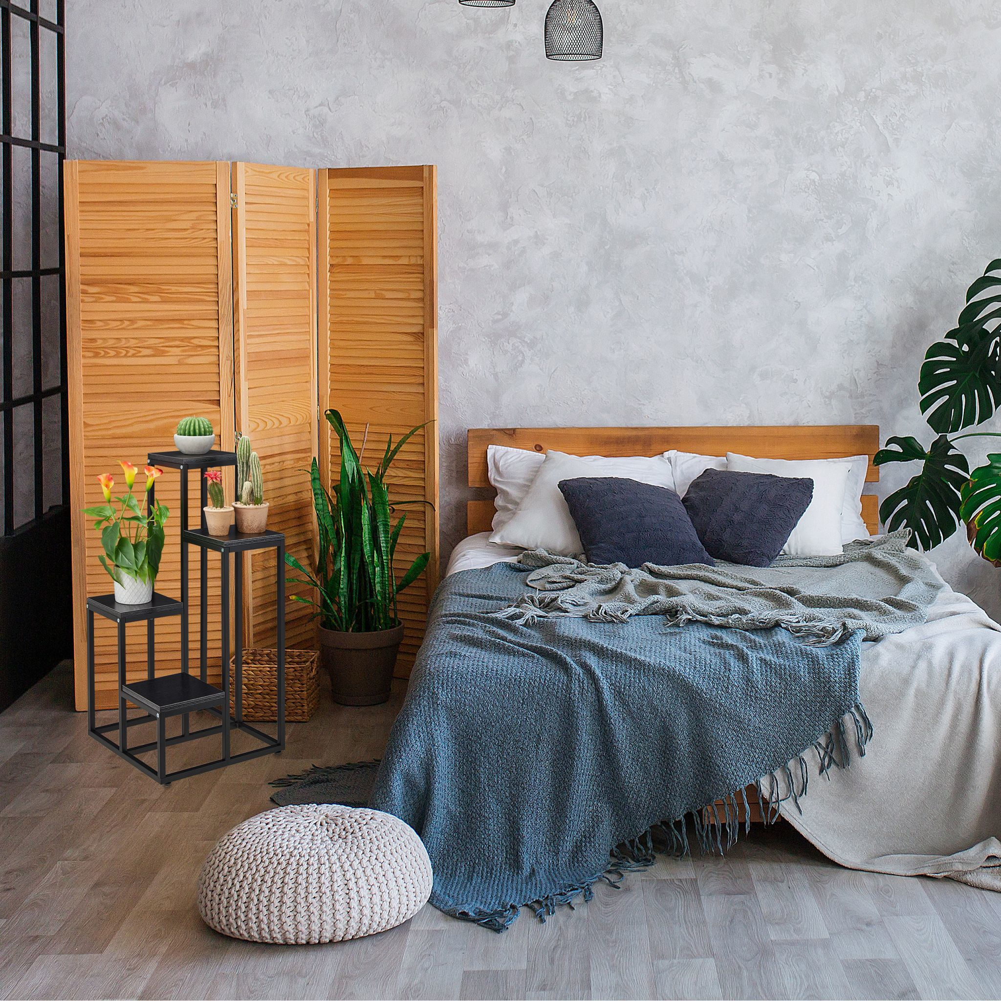 Schlafzimmer mit Bett, Pflanzen und einem Holzschirm. Ein schwarzer Pflanzenständer hat drei Ebenen.