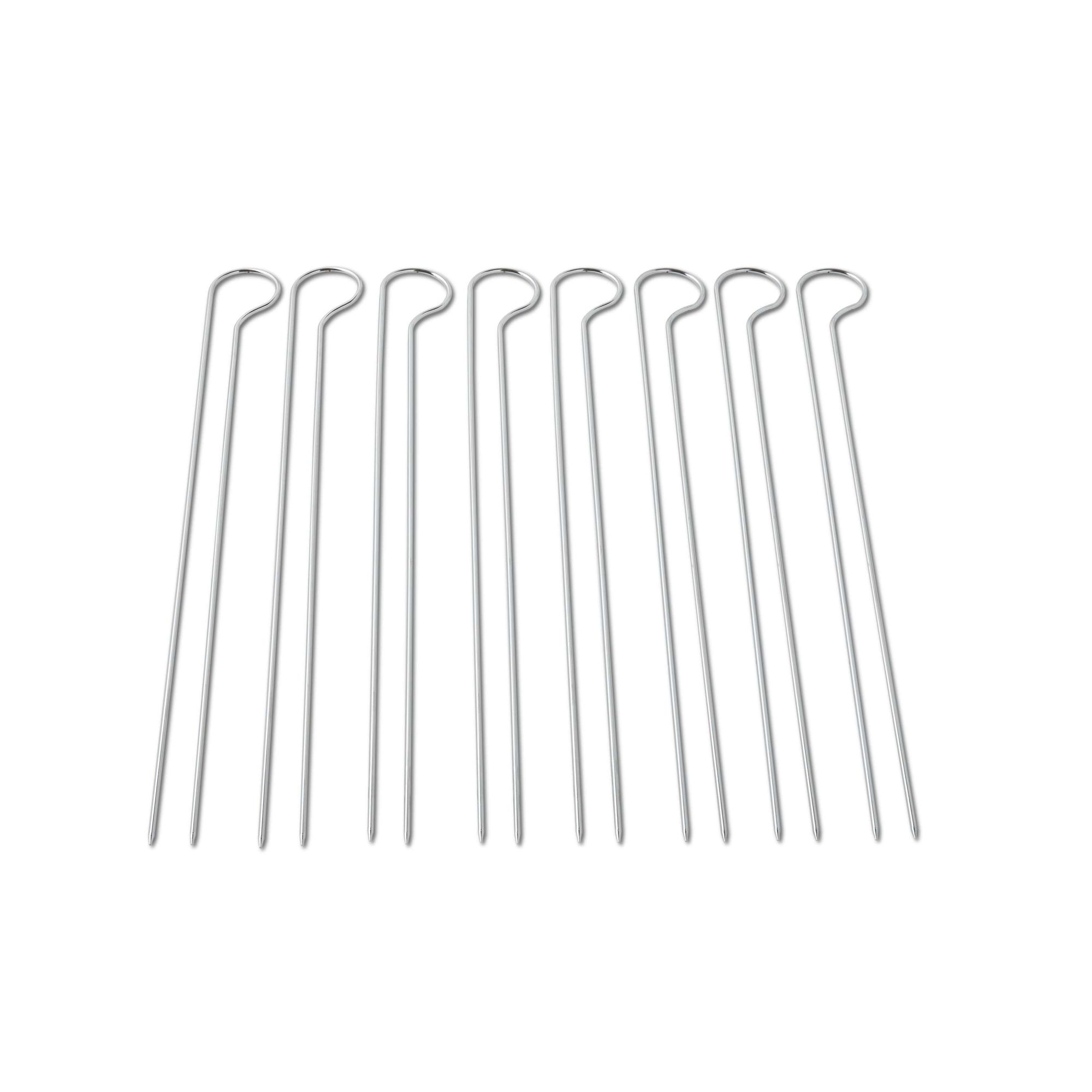 Zestaw srebrnych szaszłyków. Proste metalowe patyczki z pętelkowym zakończeniem. Prosty i czysty, białe tło.