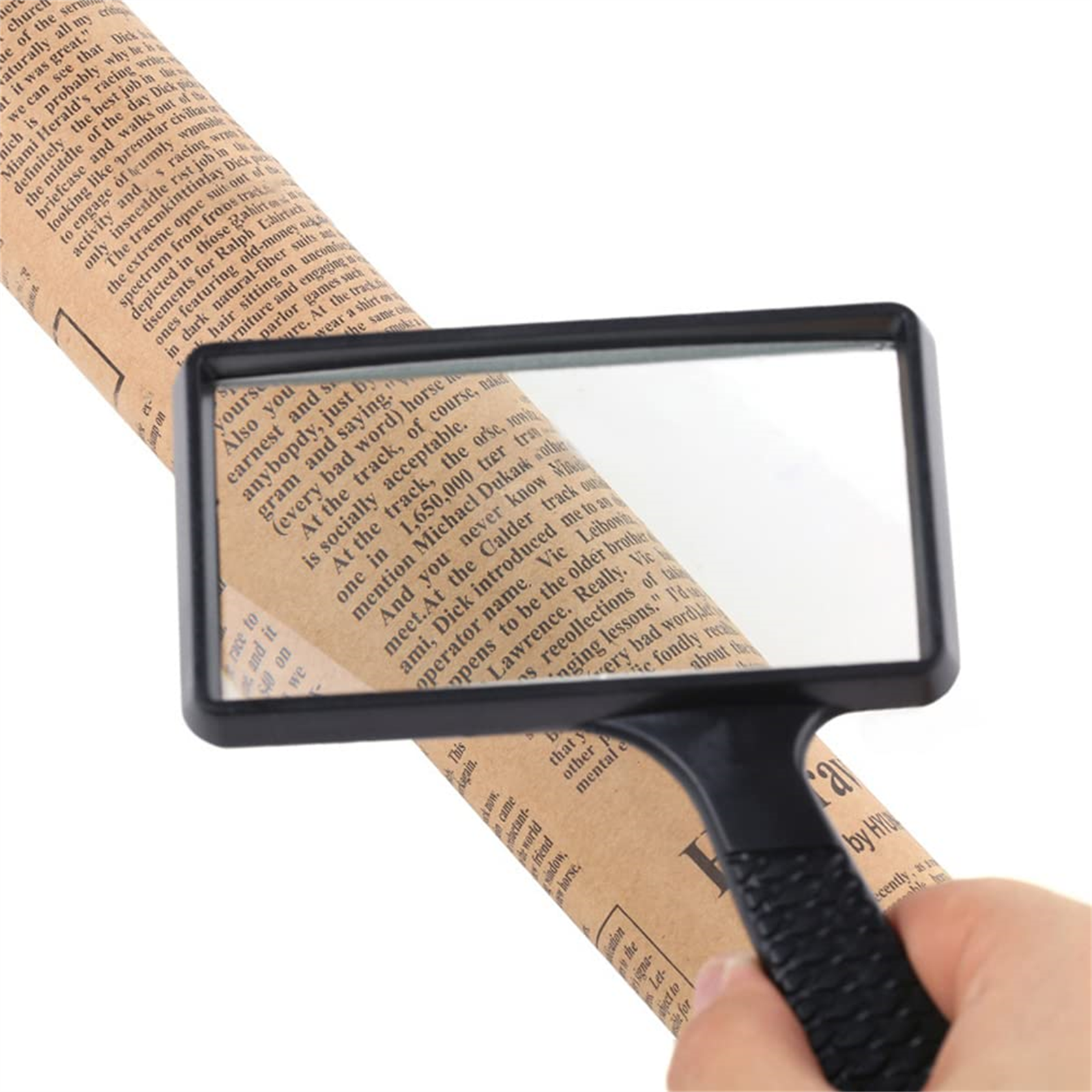 Eine Hand hält eine Lupe über einer Zeitung. Das Glas vergrößert den Text.