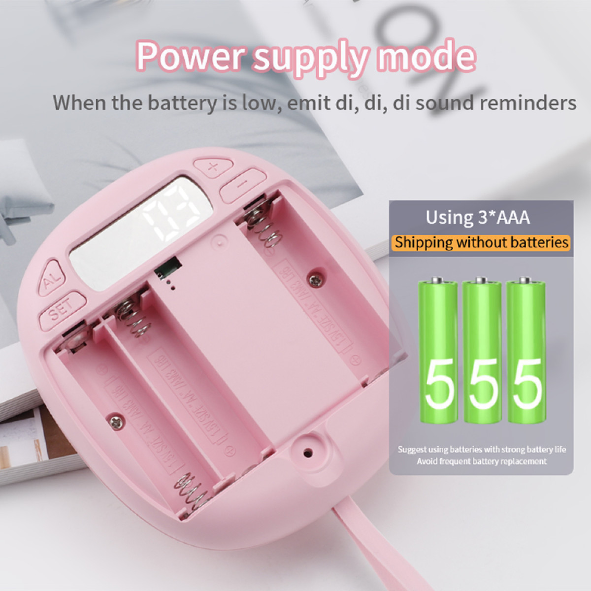 Roze digitale wekker, batterijvak open met batterijen en tekst.