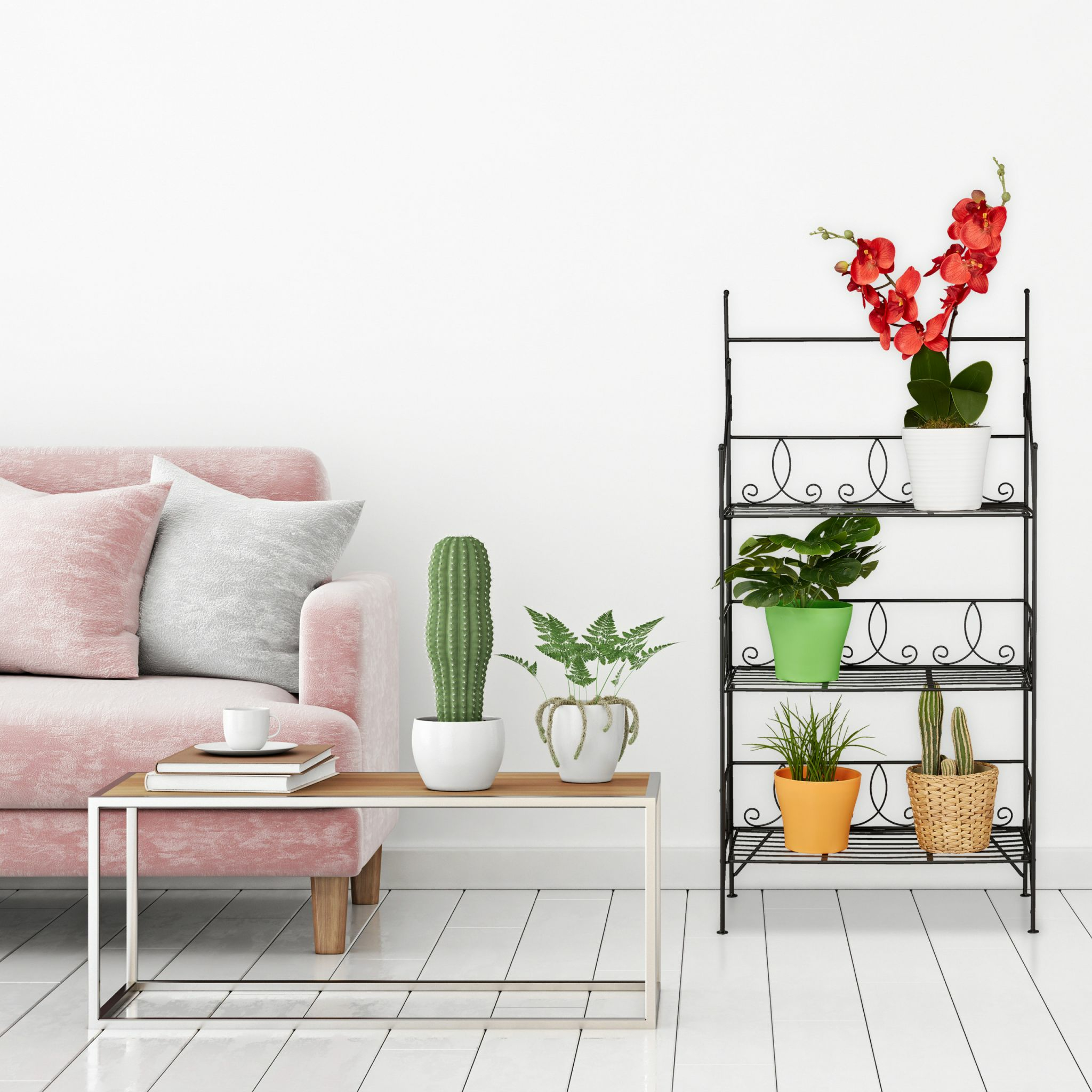 Wohnzimmer mit rosa Sofa, Pflanzen und schwarzem Pflanzenständer mit Blumen. Weiße Wände und Boden.