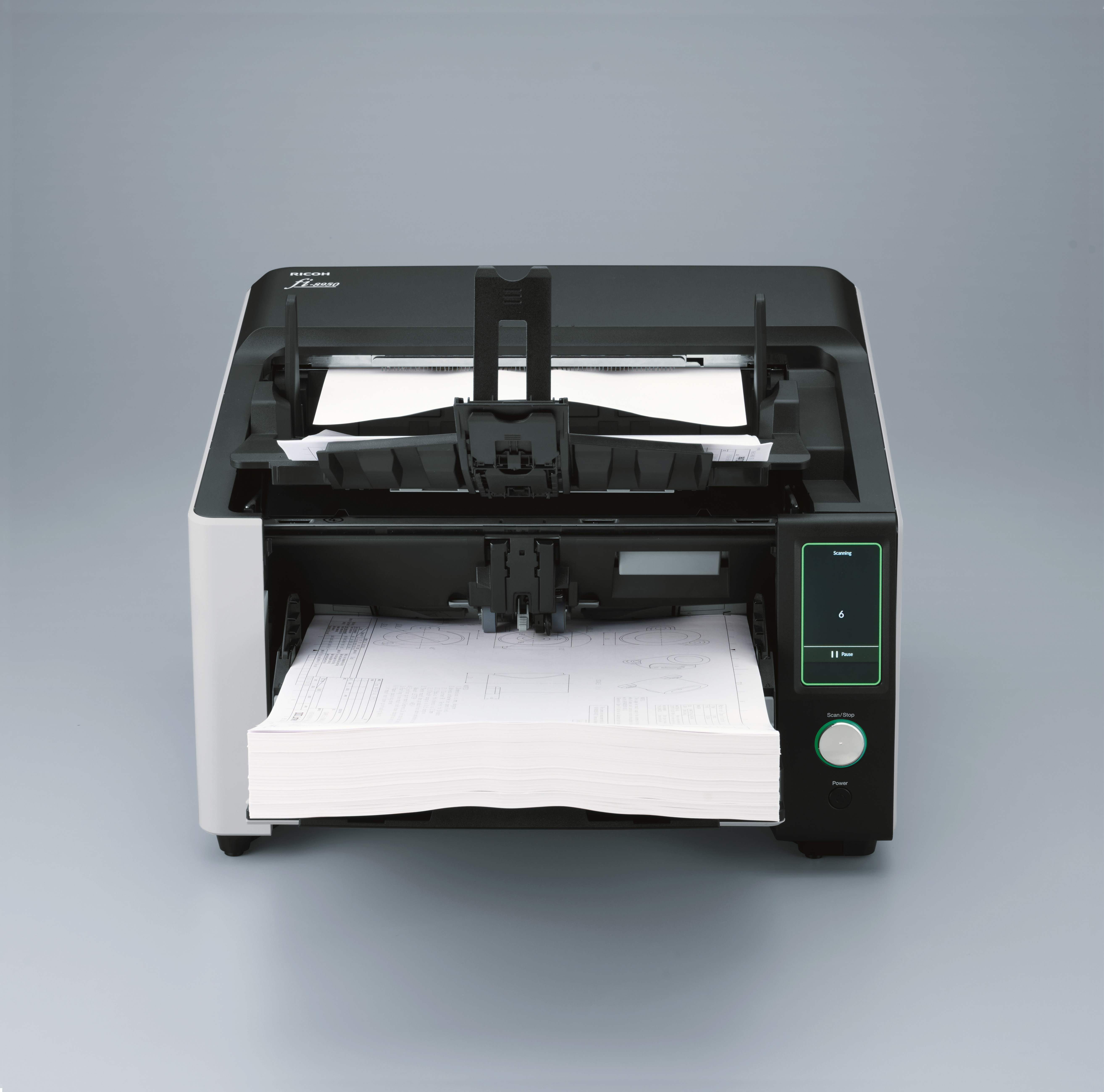 Een documentenscanner op een grijze achtergrond. Er ligt papier in de uitvoerlade.