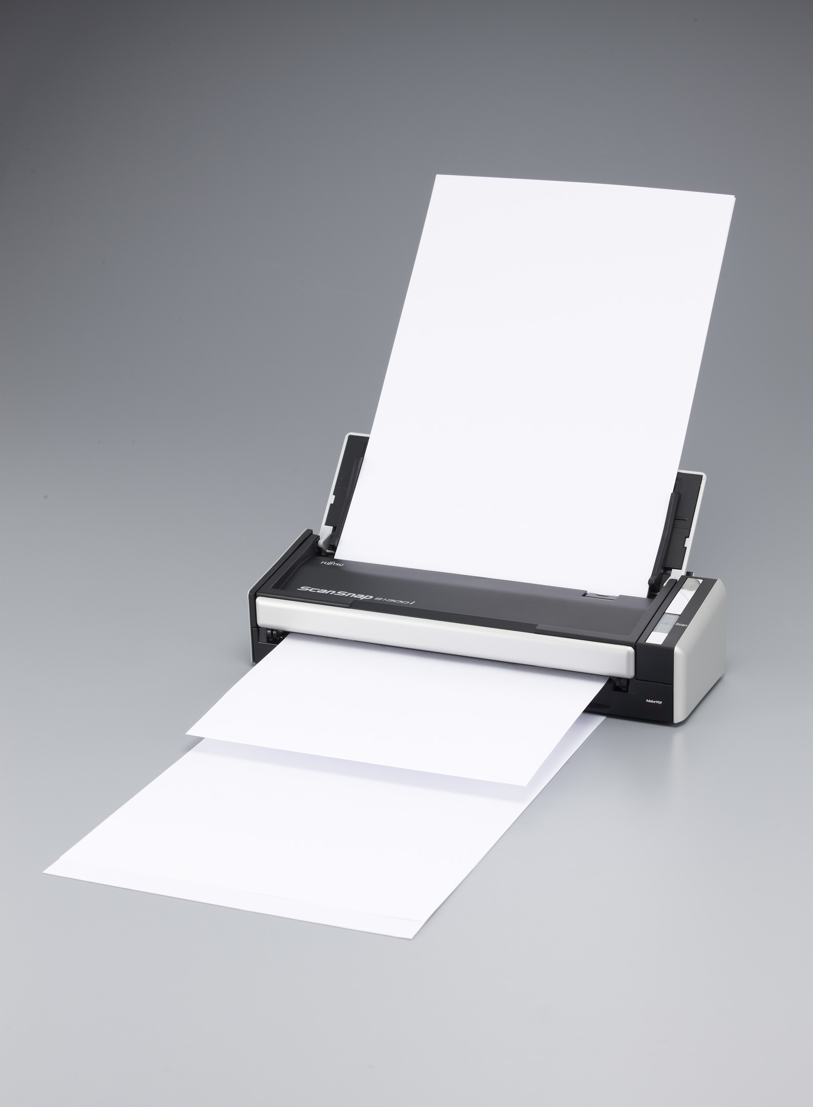 Skaner z dwoma białymi kartkami wychodzącymi. Skaner jest czarno-szary.