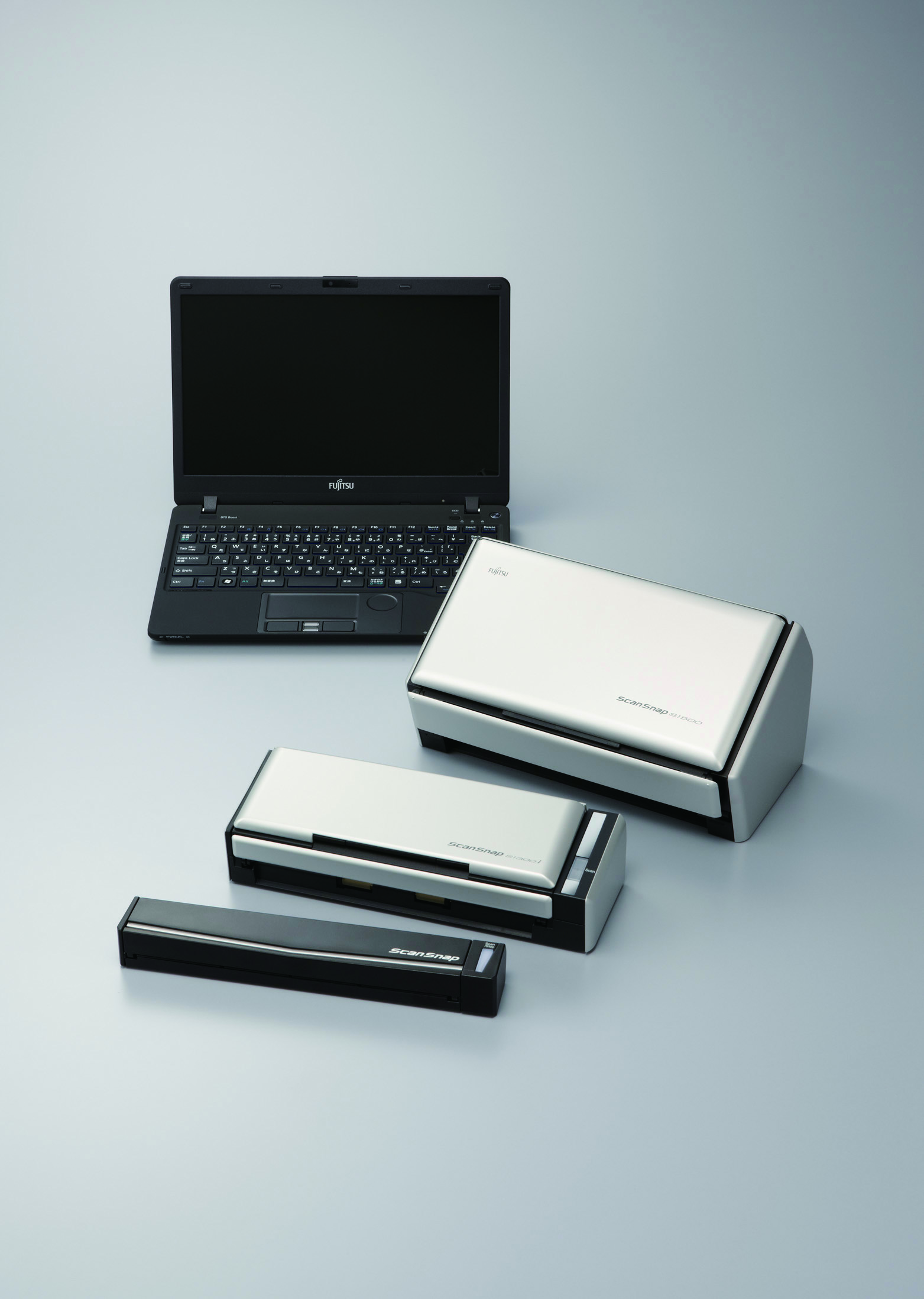 Wiele skanerów i laptop. Szare tło. Skanery znajdują się na szarej powierzchni.