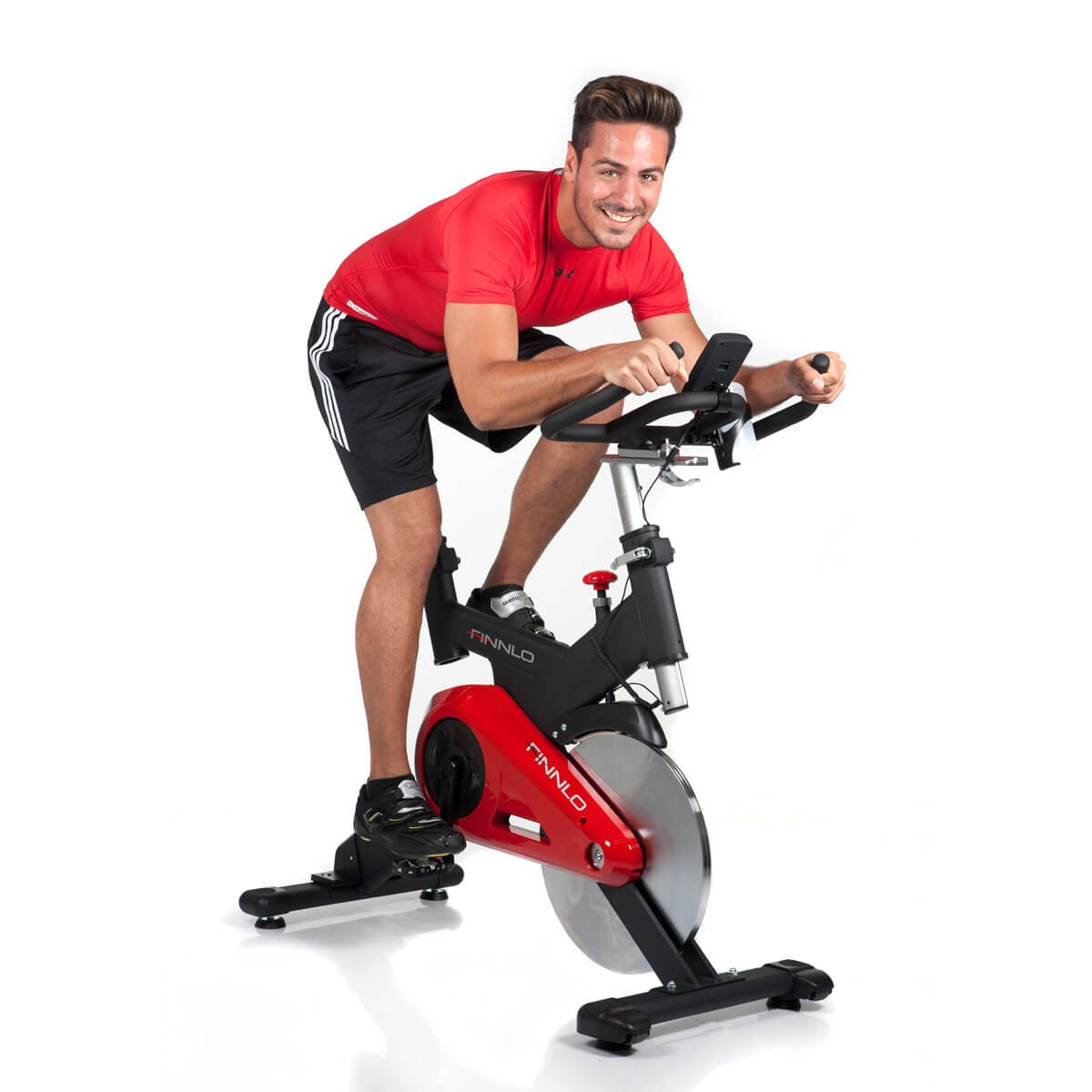 Mann lächelt und fährt auf einem roten Heimtrainer vor weißem Hintergrund.