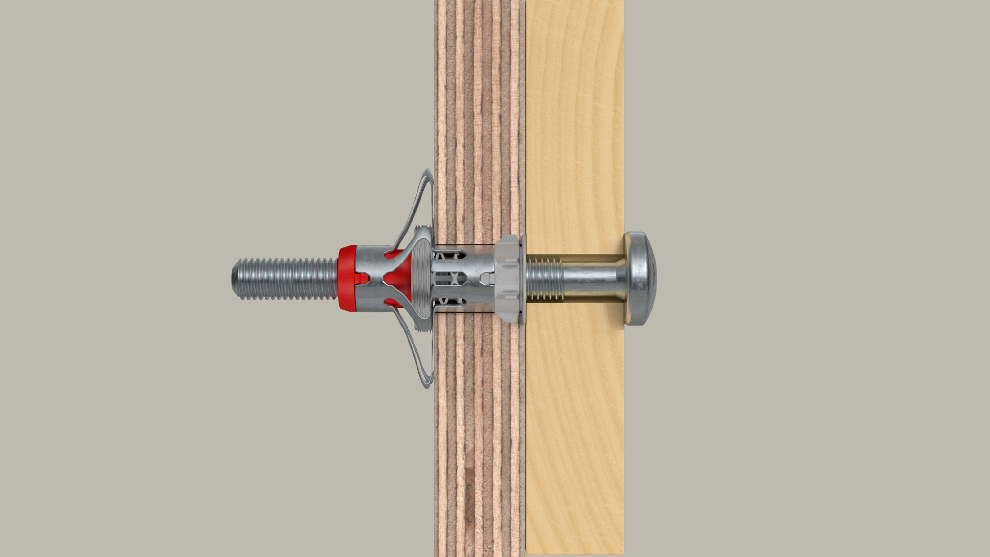Śruba i czerwono-srebrzysta kotwa rozprężna są włożone w konstrukcję z drewna i sklejki.