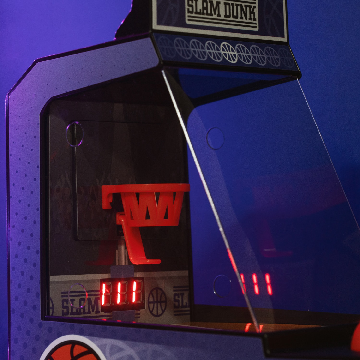 Un primo piano di un mini gioco arcade, con focus sul canestro da basket.