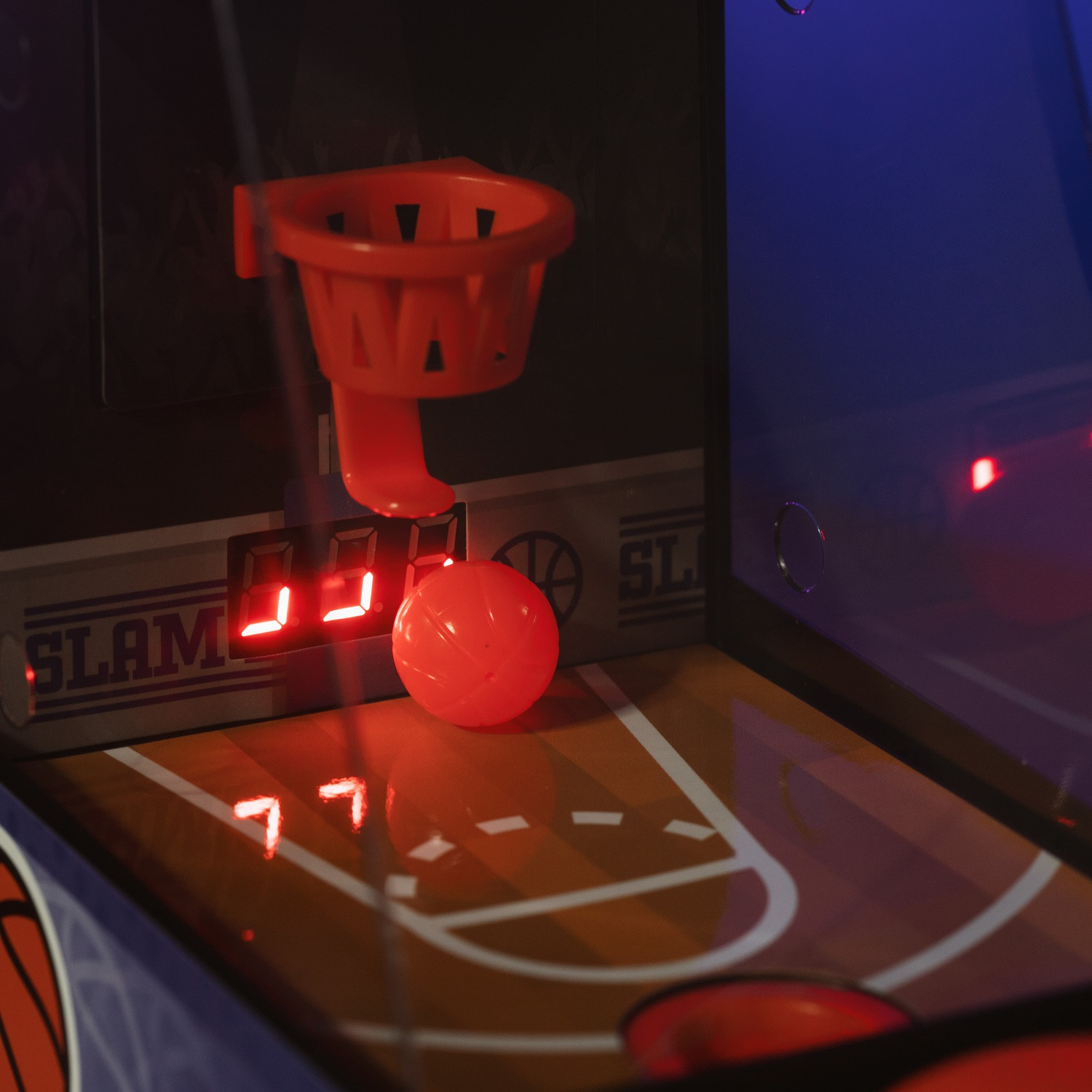 Un primo piano di un mini gioco arcade con un pallone e un canestro.