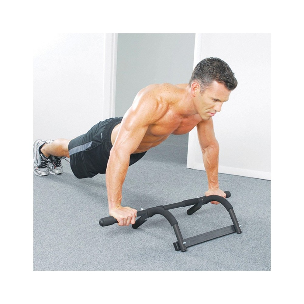 Man doing push-ups on a black bar, indoors.