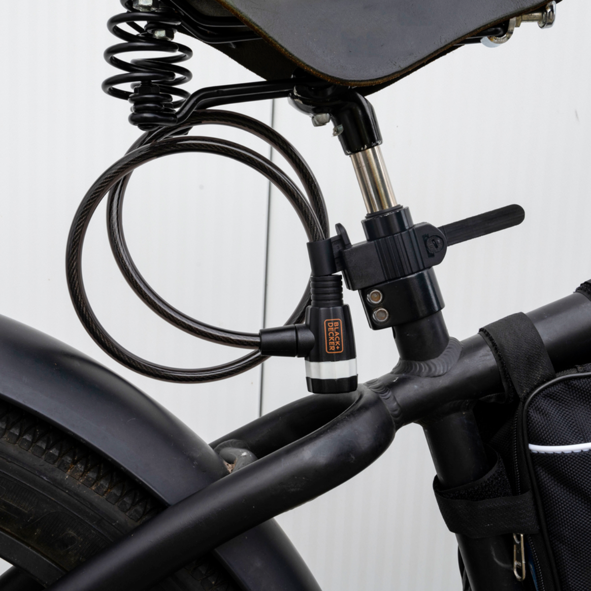 Zwart fietsslot bevestigd aan een fiets. Slot is Black & Decker. De kabel is opgerold.