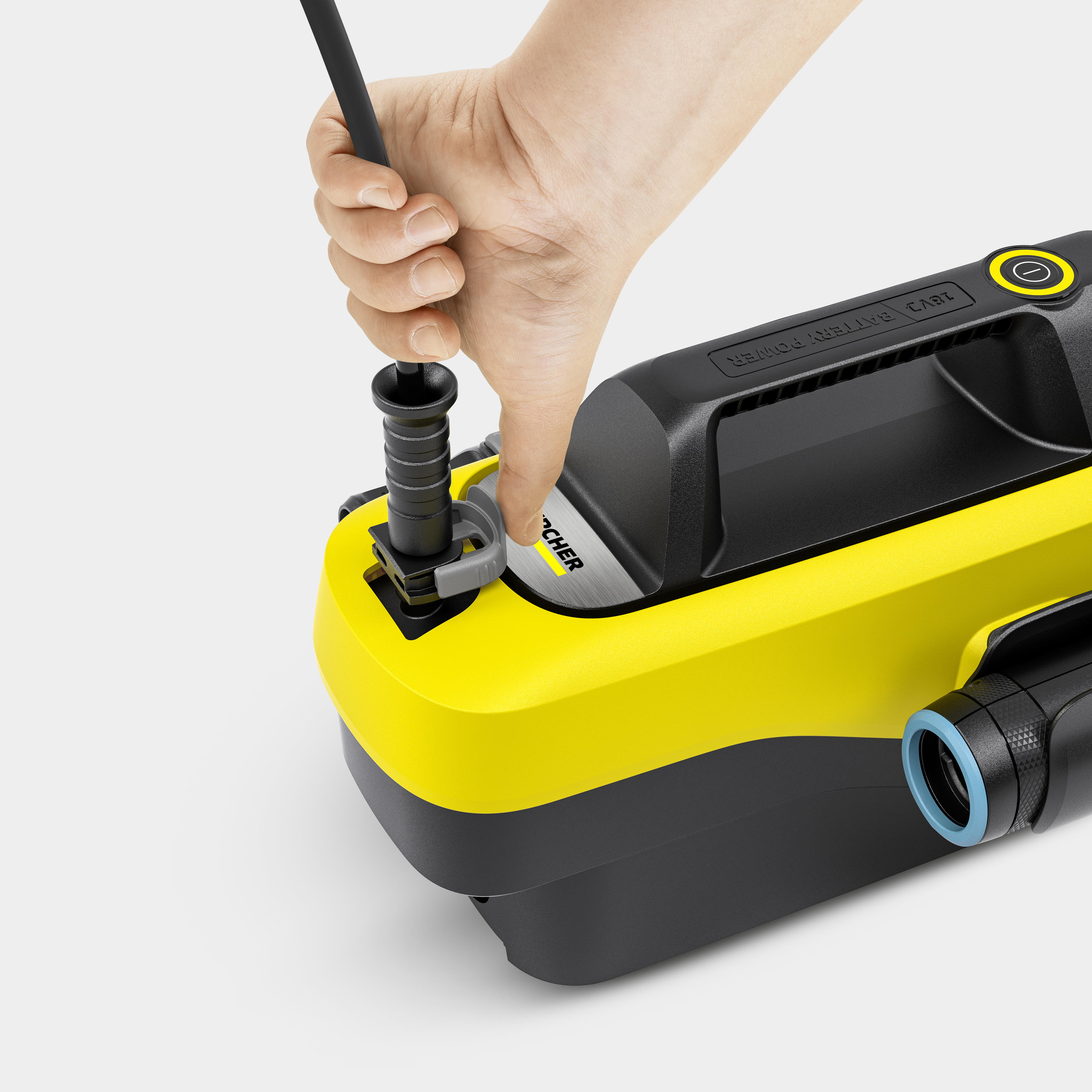 Hand inserting a black piece into a yellow and black cleaning device. Close-up shot.