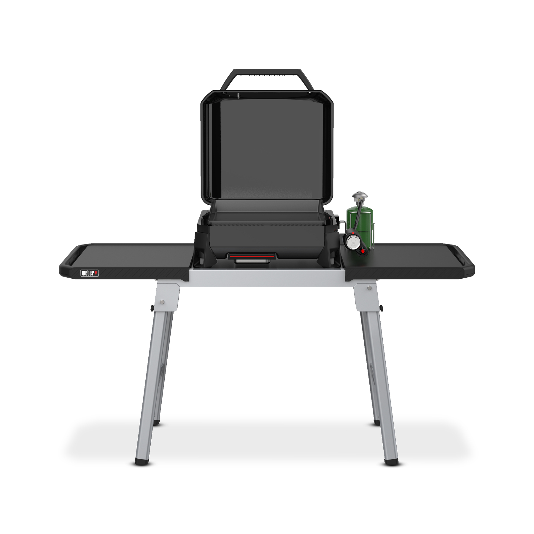 Mały przenośny grill z otwartą pokrywą. Stoi na stole z bocznymi tacami. Obecna jest butla z gazem.
