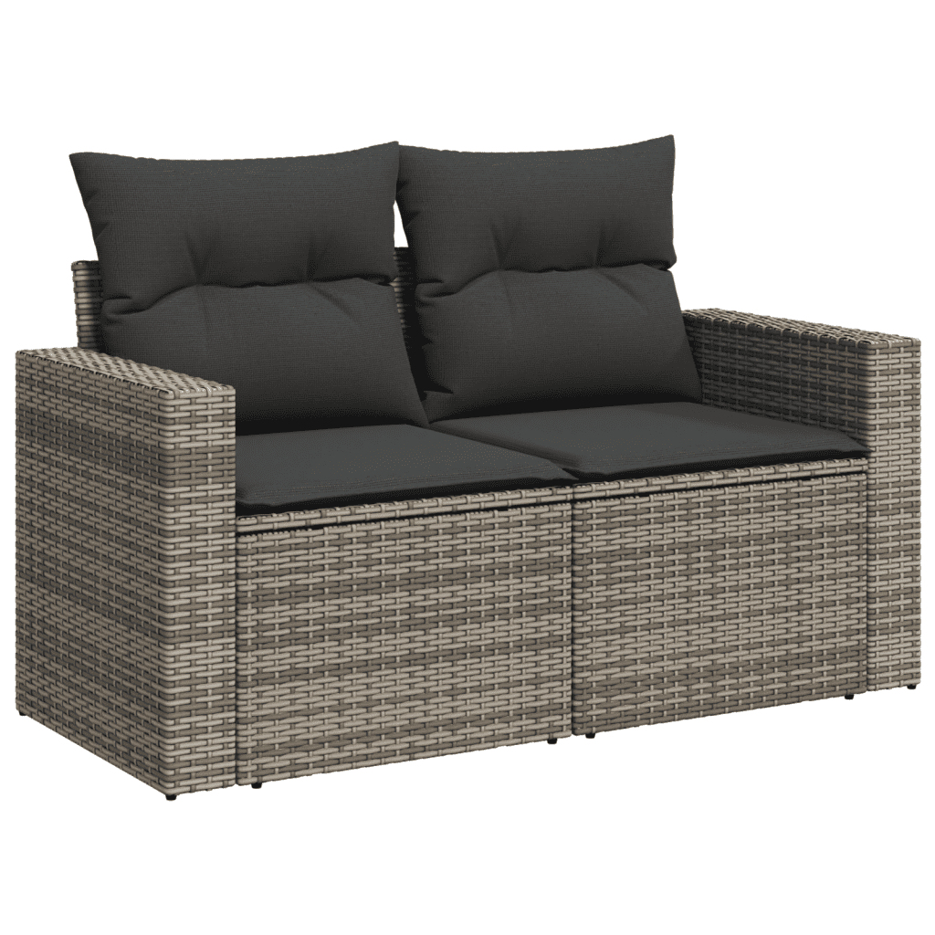 Graues Korbmöbel mit zwei Kissen. Die Kissen sind schwarz. Das Sofa steht auf weißem Hintergrund.