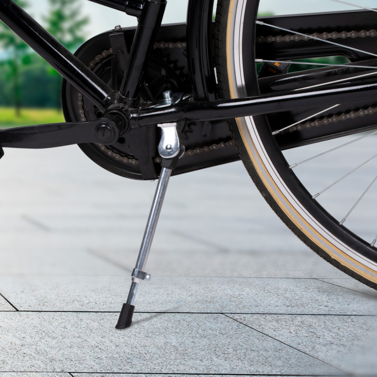 Een fiets met een standaard uitgeklapt, op een verharde ondergrond.