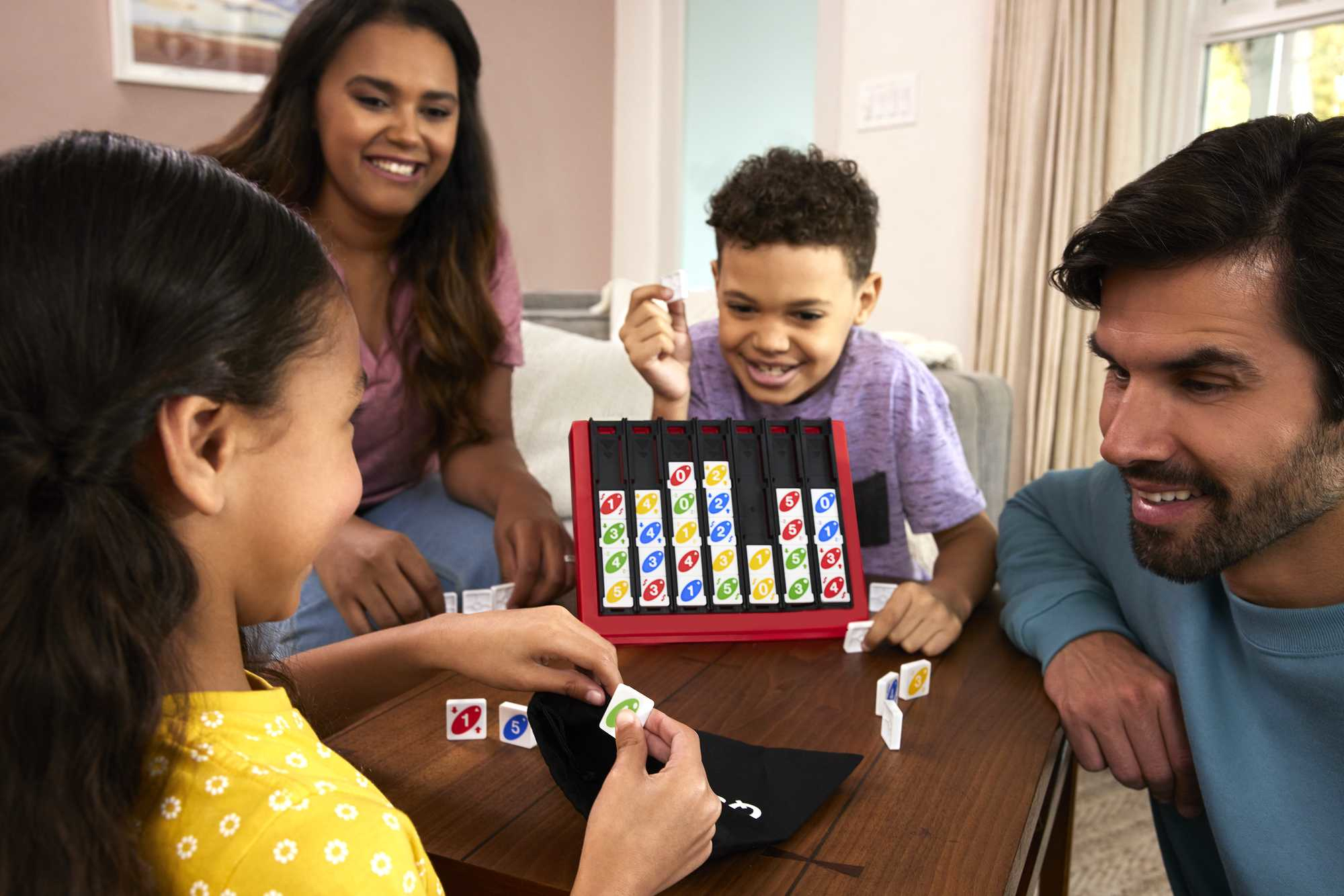Famiglia che gioca a un gioco da tavolo. Il gioco ha blocchi colorati. La gente sorride.
