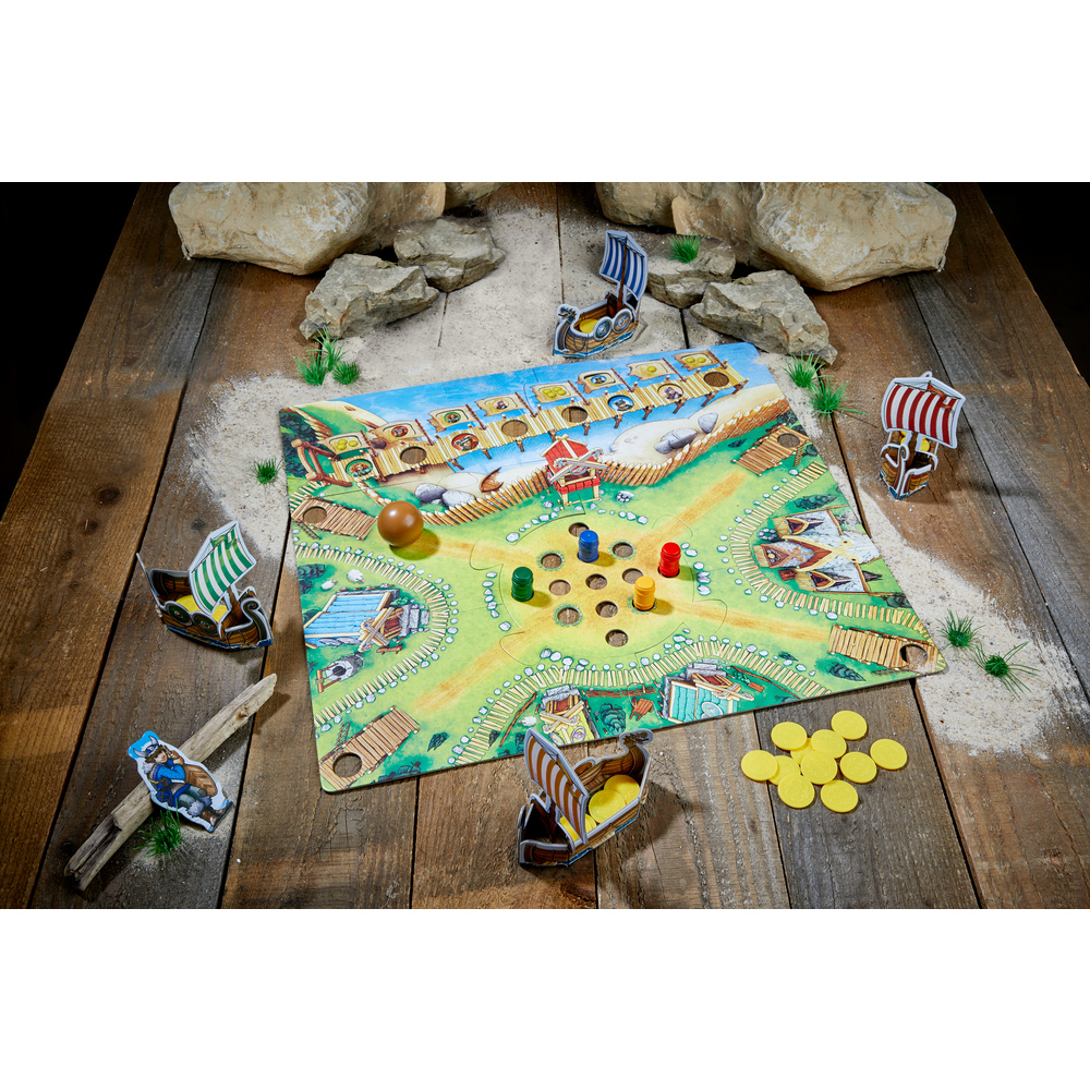 Brettspiel mit Holzbooten, Figuren und Würfeln. Es steht auf einem Holztisch mit Sand.