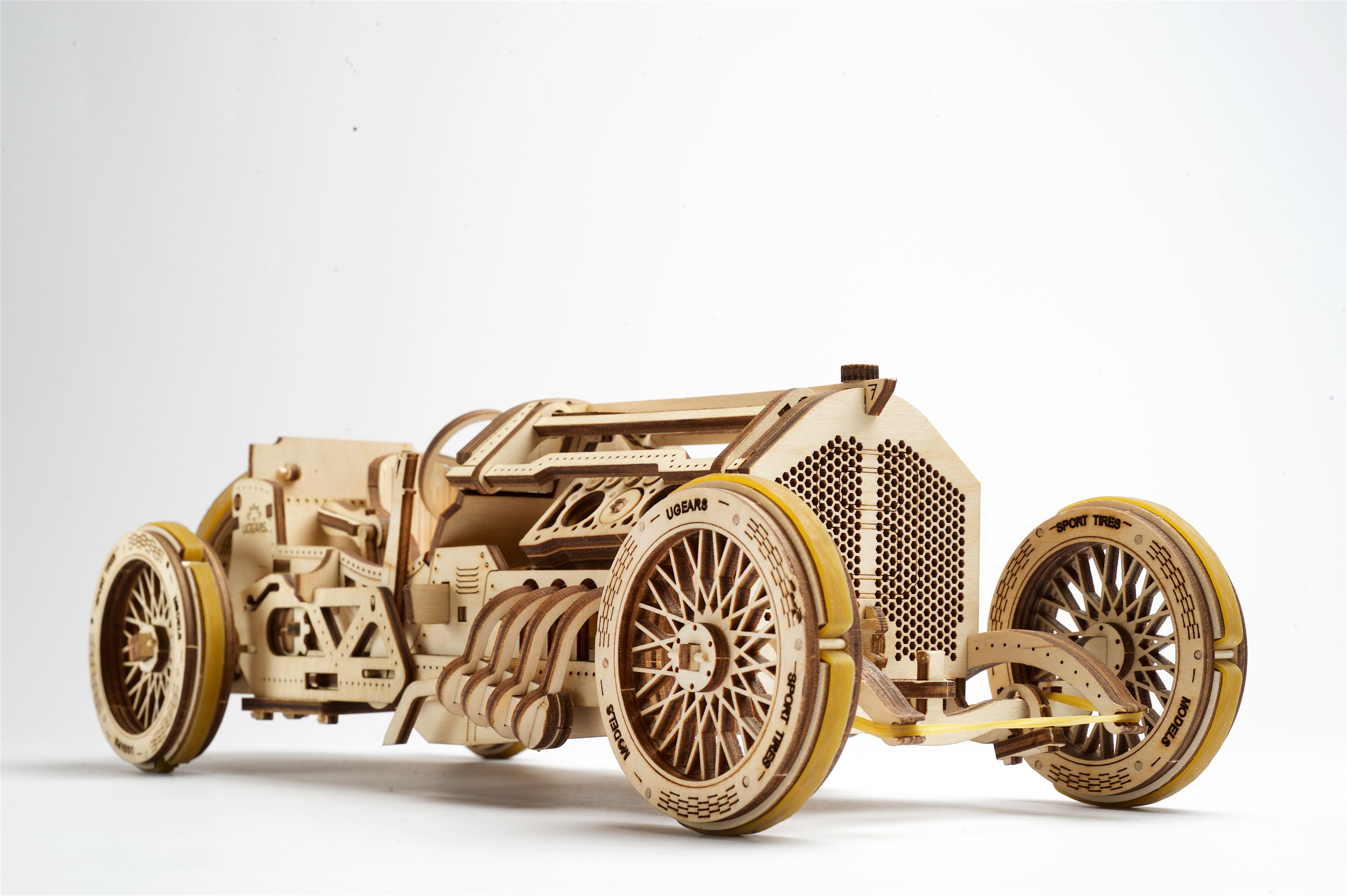 Ein Holzautomodell, ein Fahrzeug im Vintage-Stil auf weißem Hintergrund.