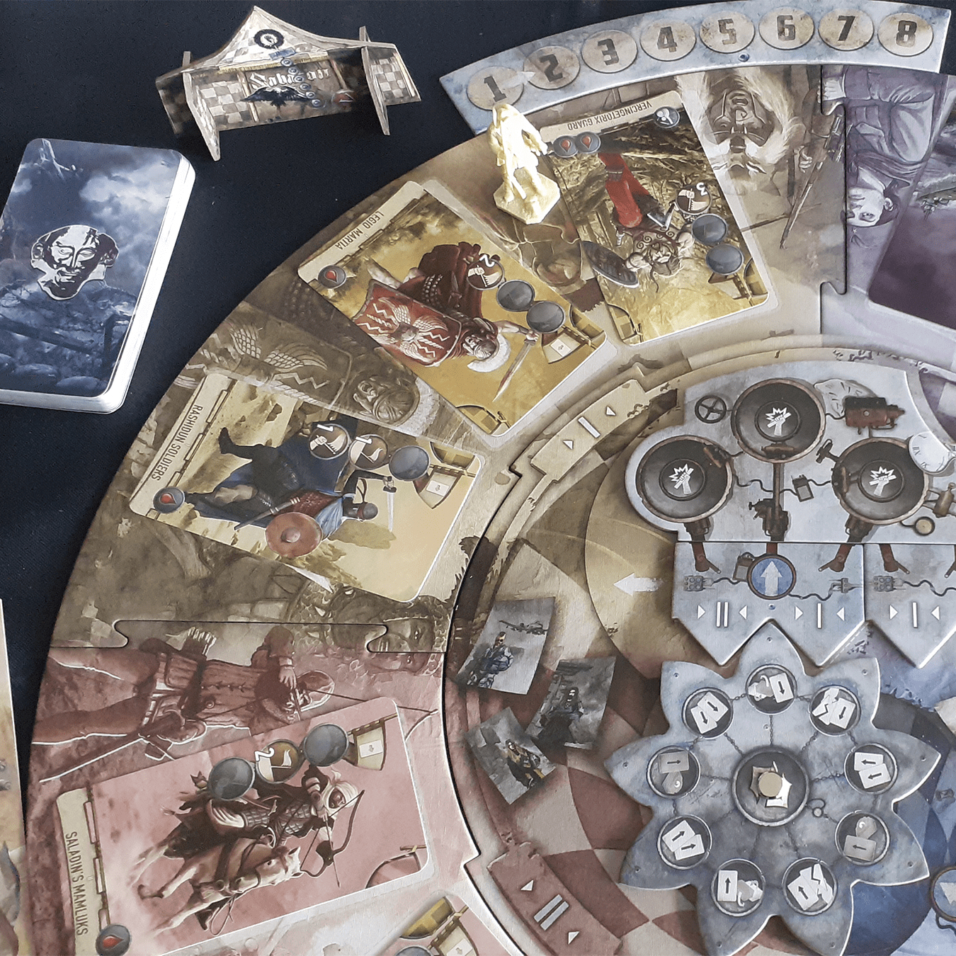 Ein Brettspiel mit Karten und Spielsteinen. Das Spielbrett hat Illustrationen von Rittern und Schilden.