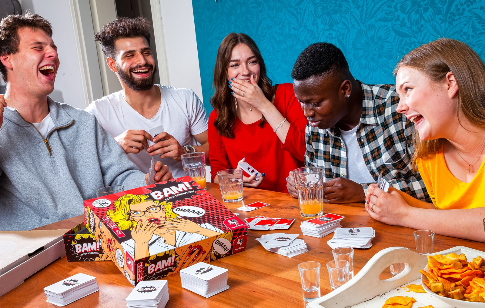 Grupa przyjaciół grających w grę planszową, śmiejących się i dobrze się bawiących.