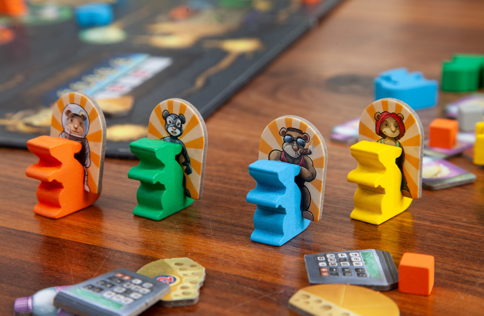 Vier farbige Holzspielsteine mit Cartoon-Bärengesichtern auf einem Tisch.