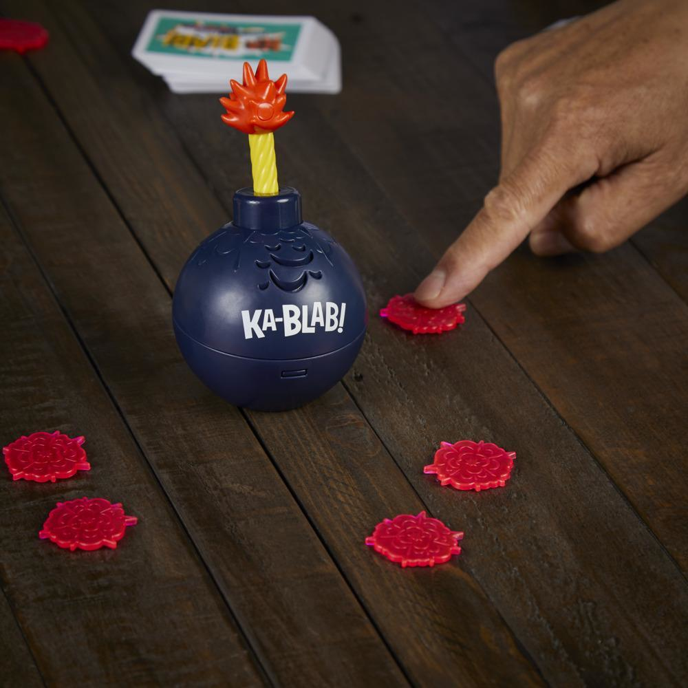 Ein Spielset mit einer Bombenattrappe und roten blumenförmigen Teilen auf einem Holztisch.