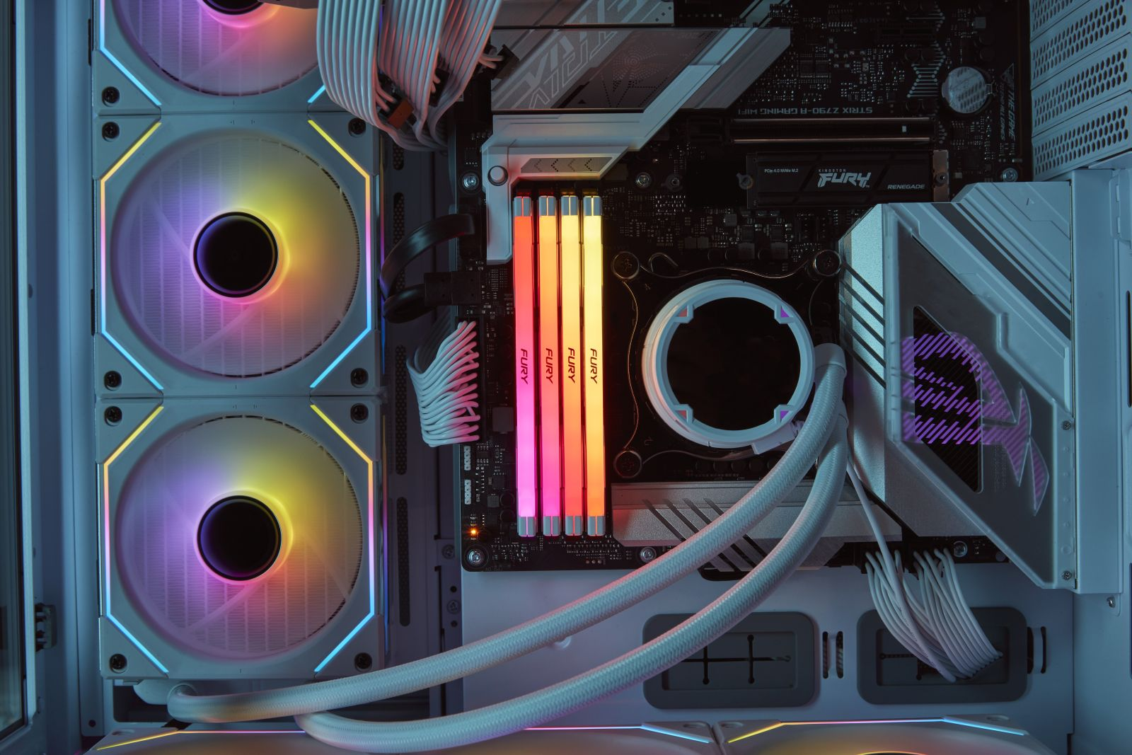 Wnętrze obudowy komputera z wentylatorami i kolorowymi kośćmi RAM. Białe, czarne i RGB światła.