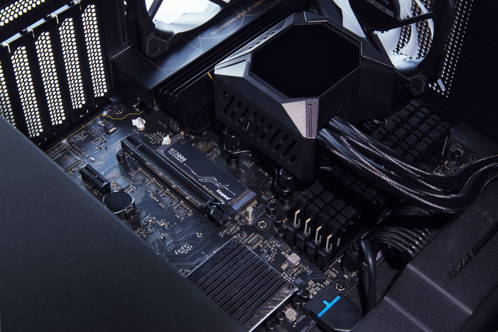 Wewnątrz obudowy komputera z płytą główną, chłodzeniem procesora i innymi komponentami. Ciemne oświetlenie.