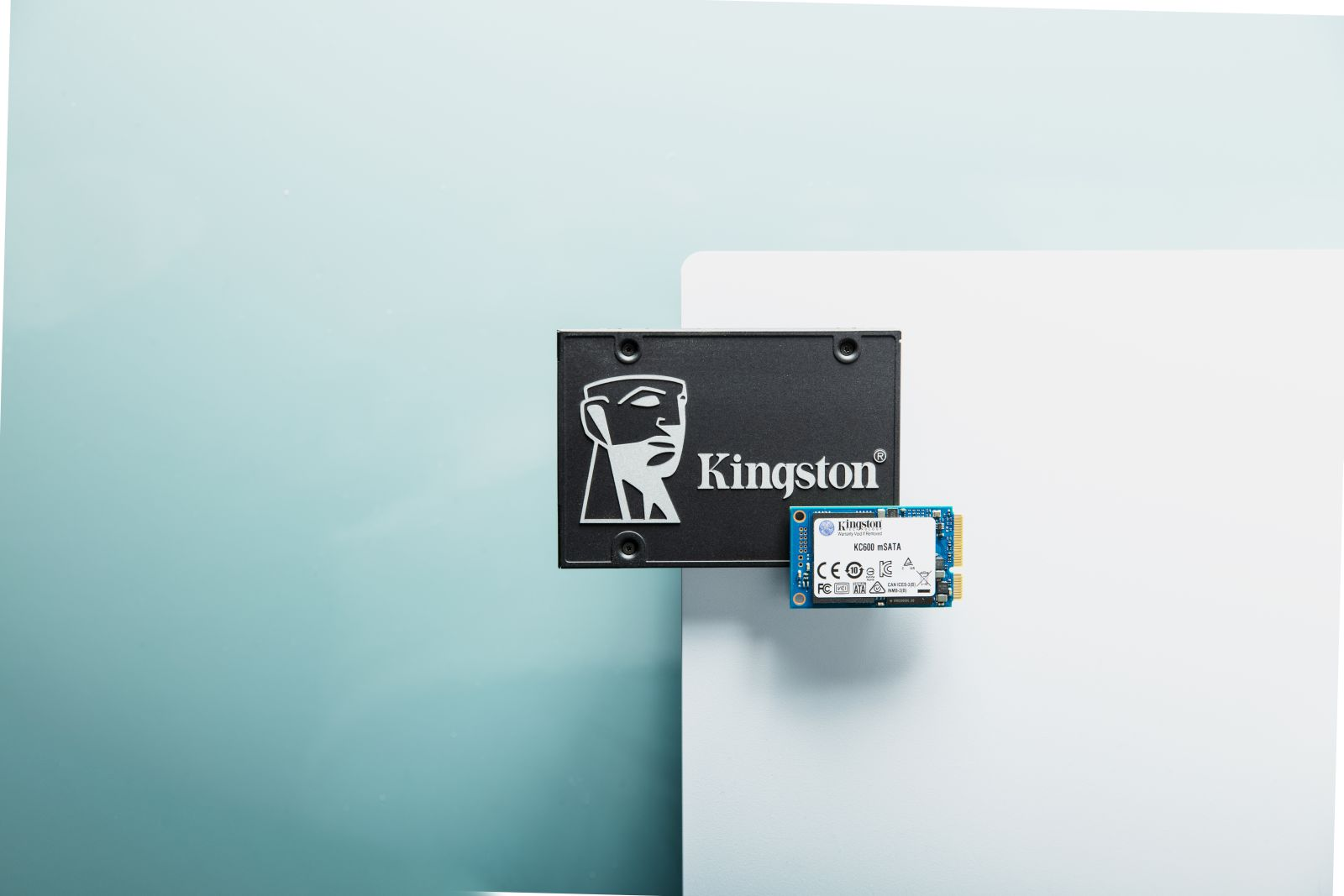 Dwa czarne dyski twarde komputera na białym i niebiesko-zielonym tle. Jeden duży, jeden mały.