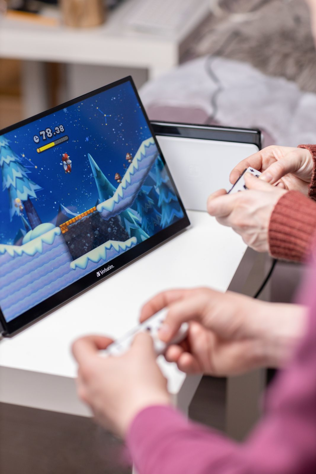 Dwie osoby grają w grę wideo na konsoli przenośnej z poziomem śnieżnym.