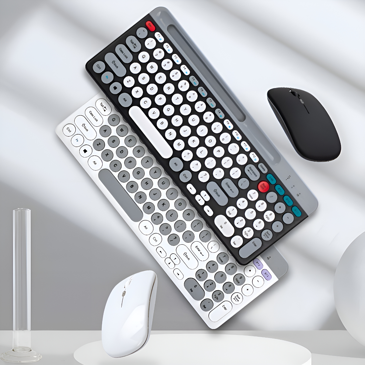 Zwei Tastaturen und zwei Mäuse. Eine Tastatur und Maus sind weiß, die andere ist schwarz und grau.