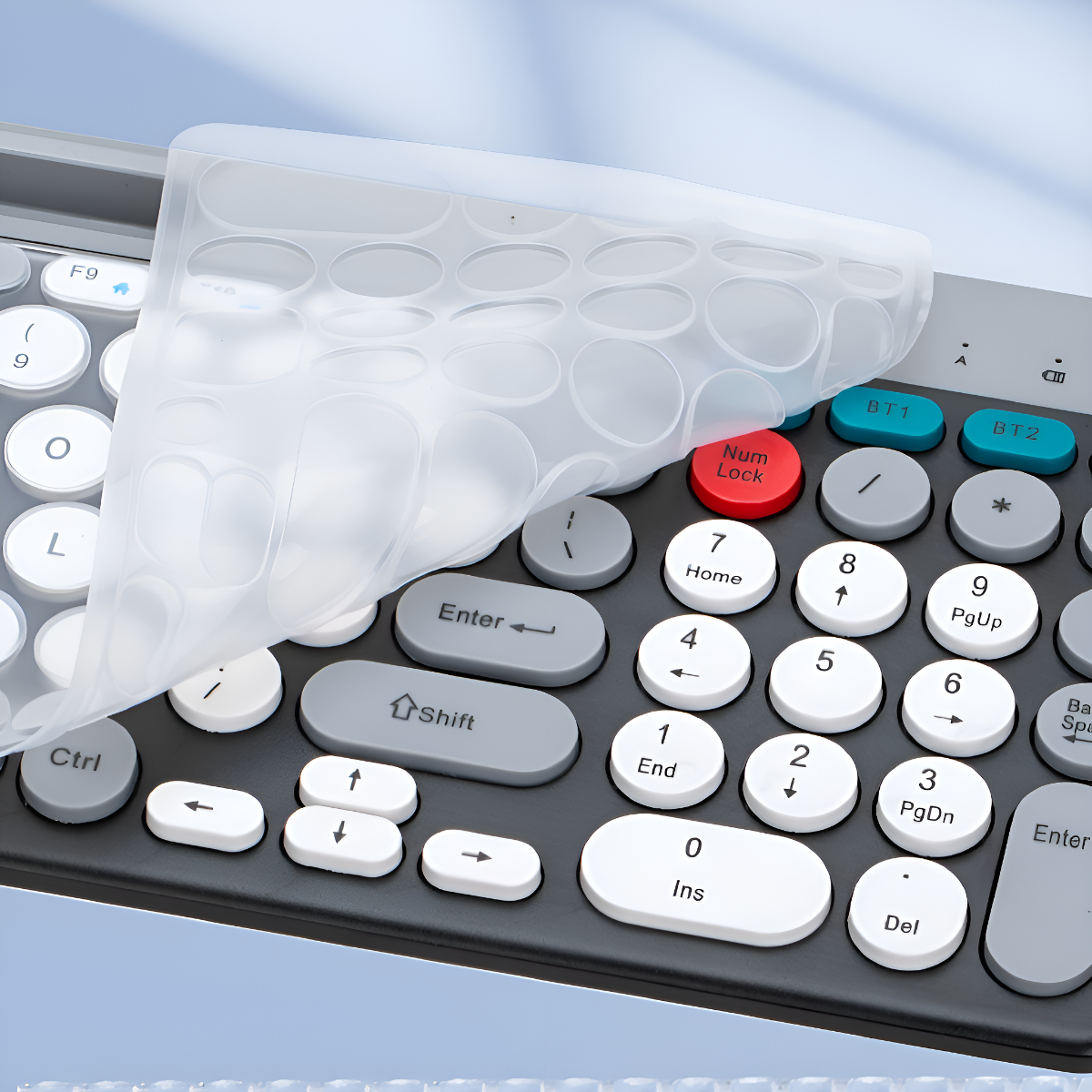Tastatur mit einer transparenten Abdeckung. Einige Tasten sind in Weiß, Grau, Rot und Blau.