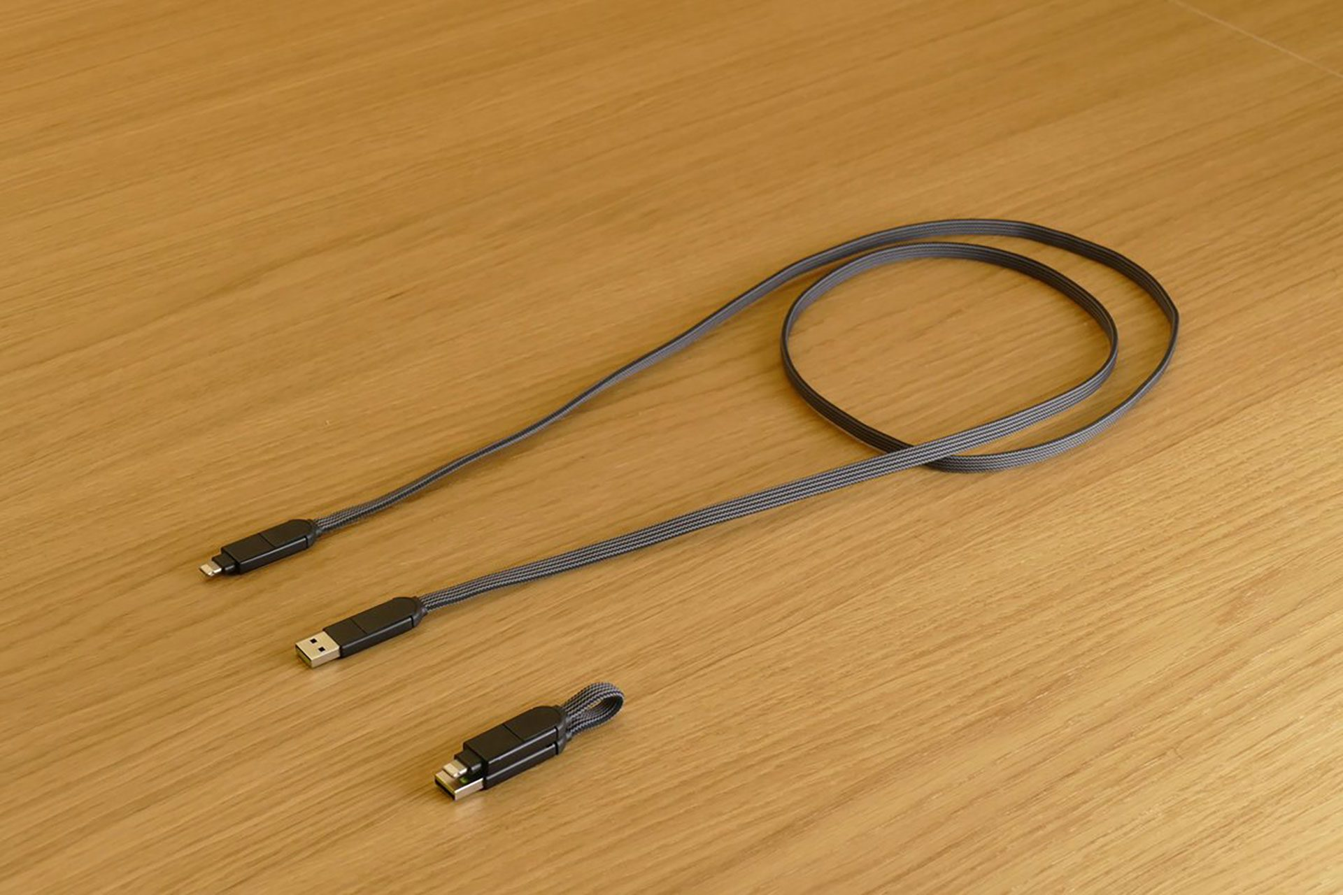 Drie oplaadkabels op een houten oppervlak, met USB- en micro-USB-connectoren.