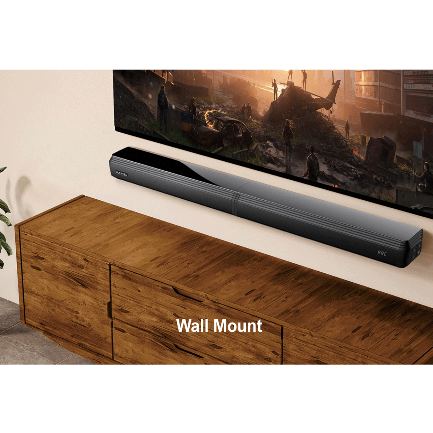 Una soundbar nera montata a parete sopra un mobile in legno con una TV. Il muro è bianco.