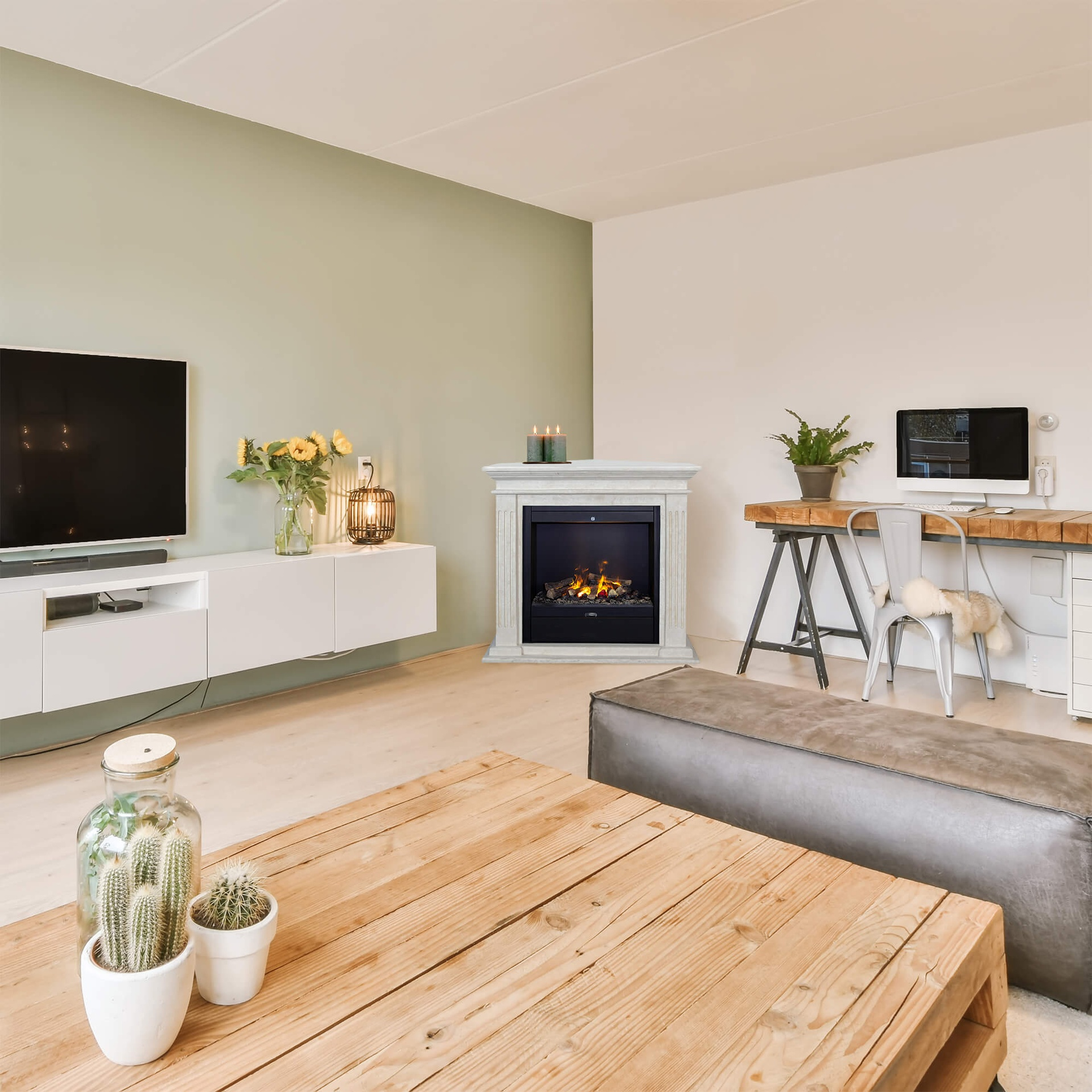 Een woonkamer met open haard, tv, salontafel en werkplek. Houten vloer en witte en saliegroene muren.