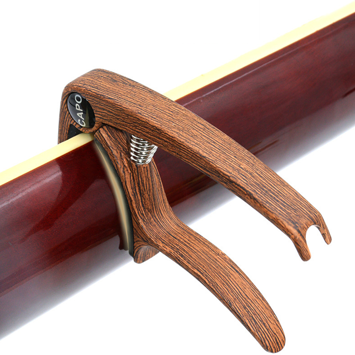 Ein Holzoptik-Kapodaster an einer Gitarre befestigt. Der Kapodaster hat eine Metallfeder und das Wort CAPO.