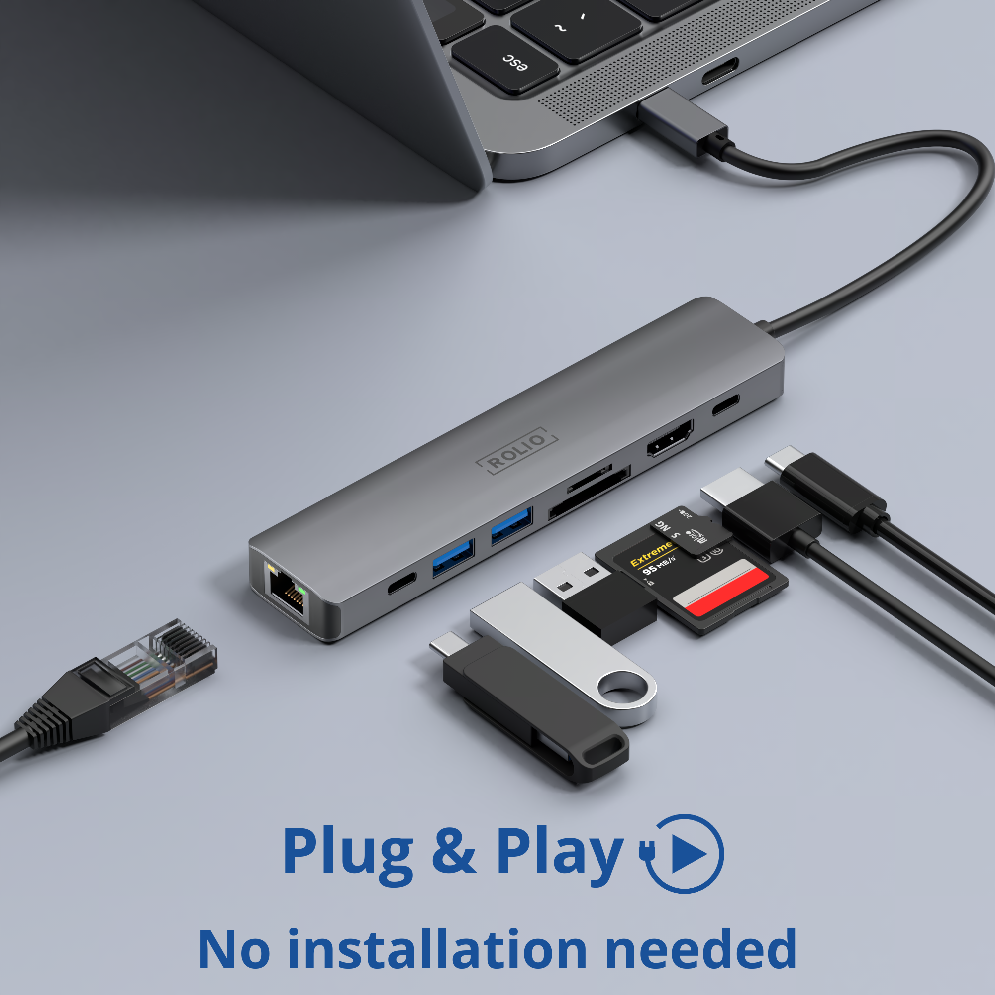 Hub argenté avec ports connectés à un ordinateur portable, cartes et câbles.