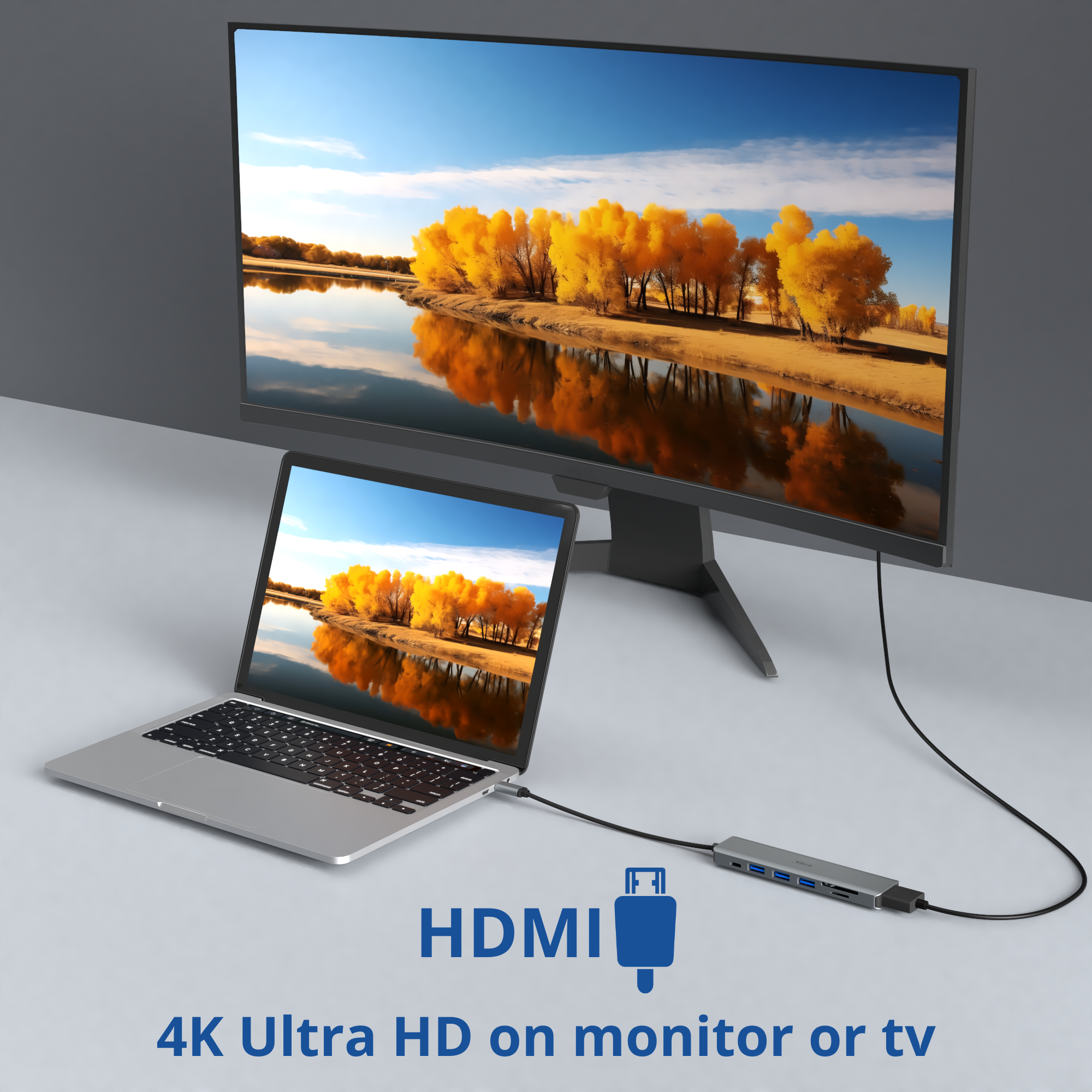 Een laptop aangesloten op een monitor via een HDMI-adapter, met een landschappelijke achtergrond.