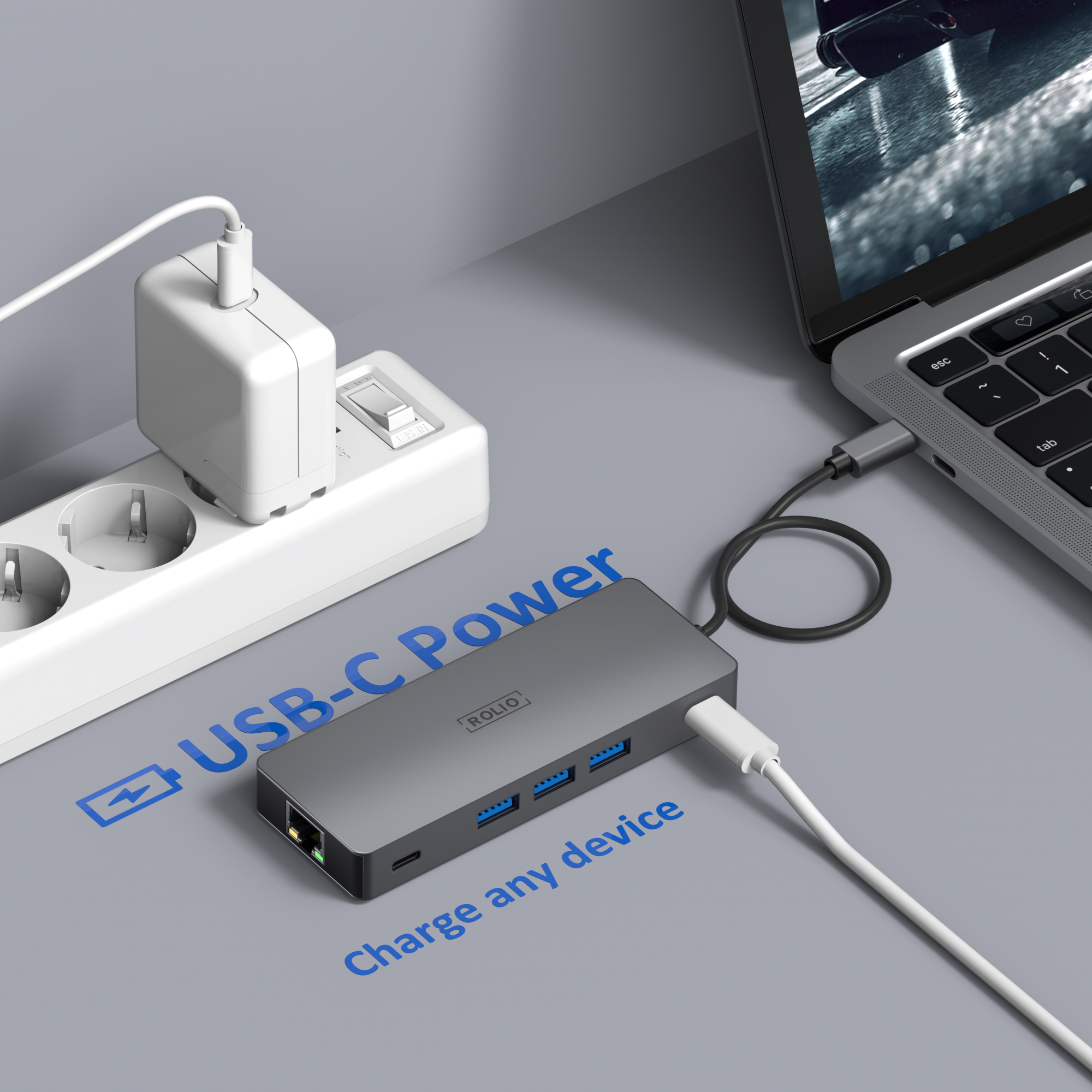 Een grijze USB-C hub aangesloten op een laptop, met een voeding aangesloten op een stopcontact.