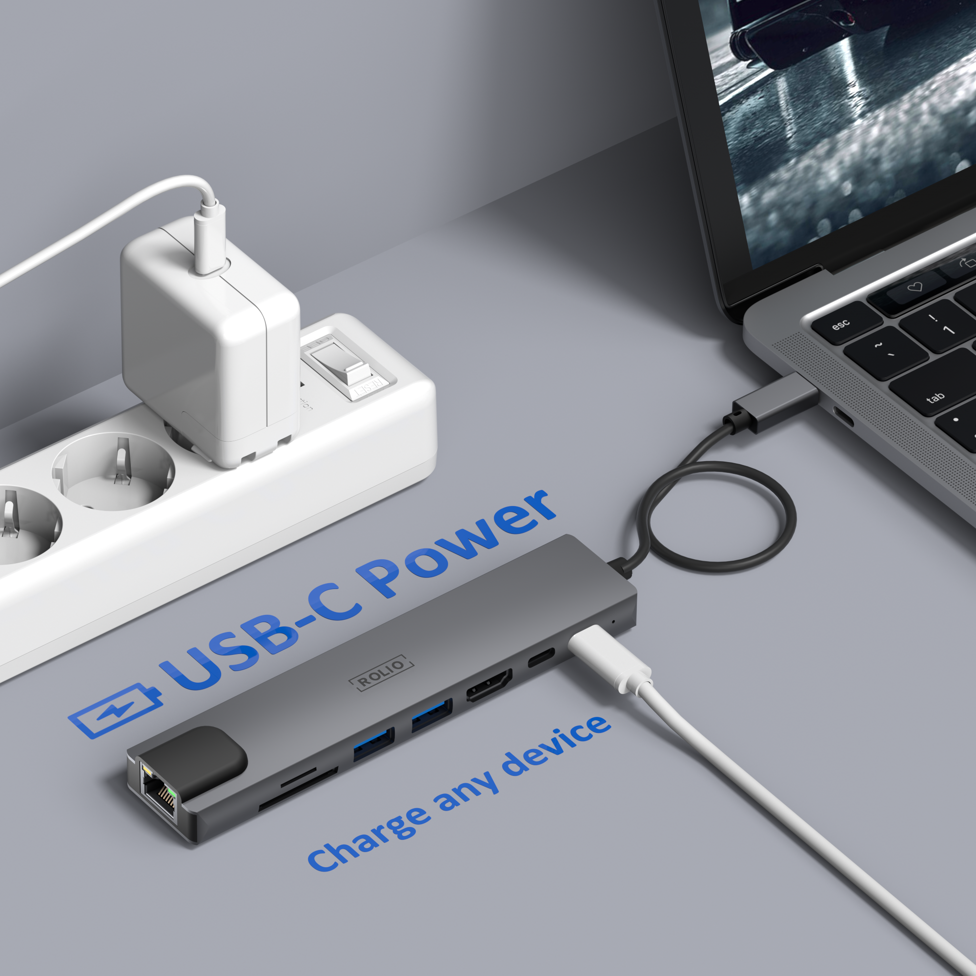 Ein Laptop, der mit einem USB-C-Hub geladen wird, der an eine Steckdose angeschlossen ist. Text: USB-C Power, charge any device.