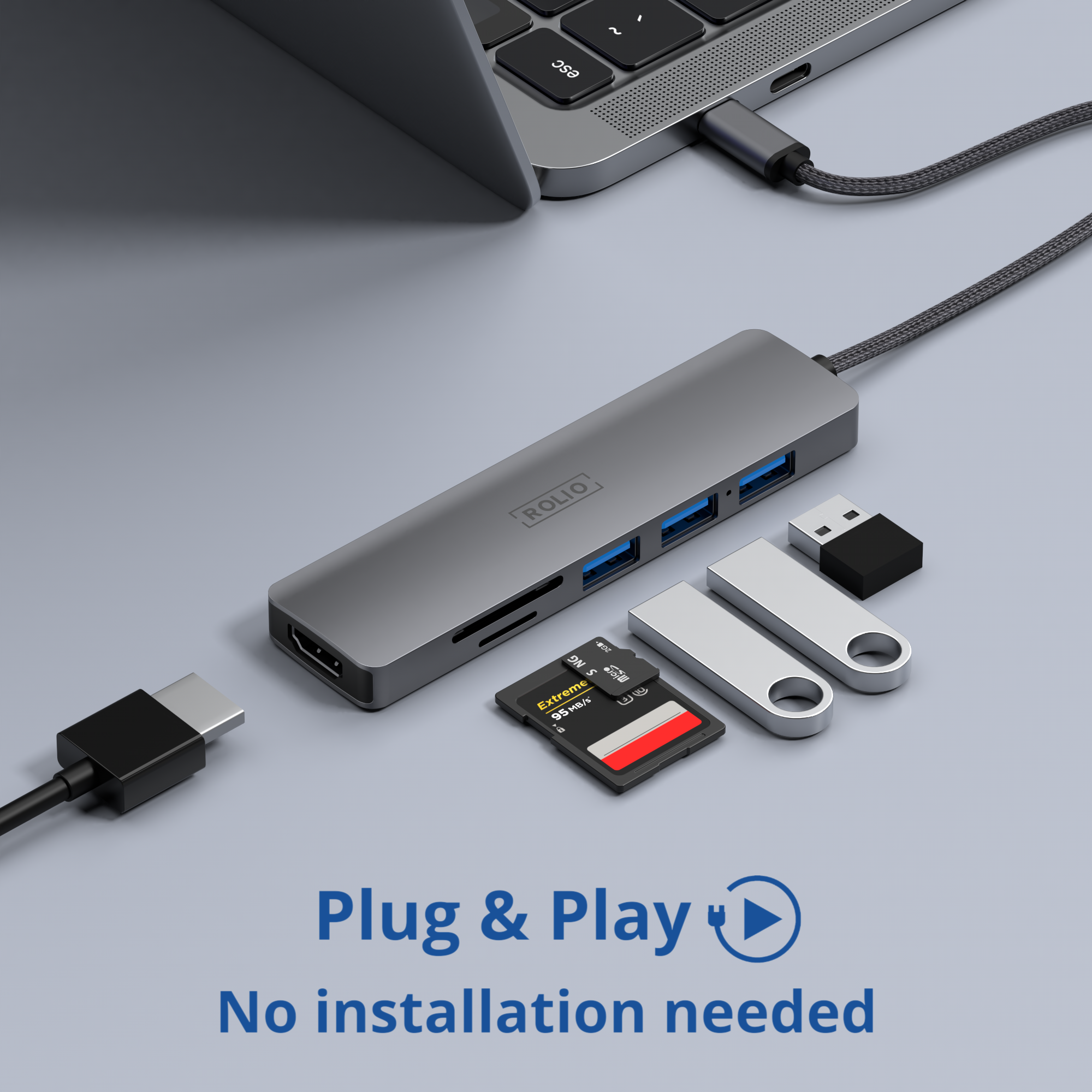 Ein silberner Hub mit mehreren Anschlüssen, USB-Laufwerke, SD-Karten und ein Laptop auf einer Oberfläche.