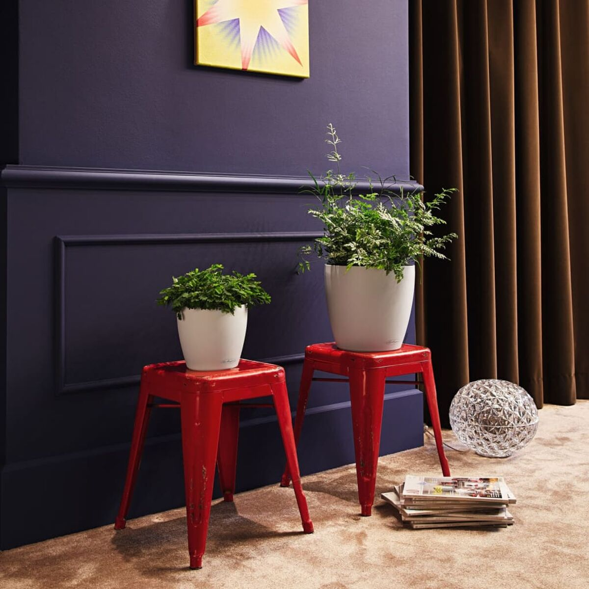 Plantes sur tabourets rouges à l'intérieur d'une pièce.